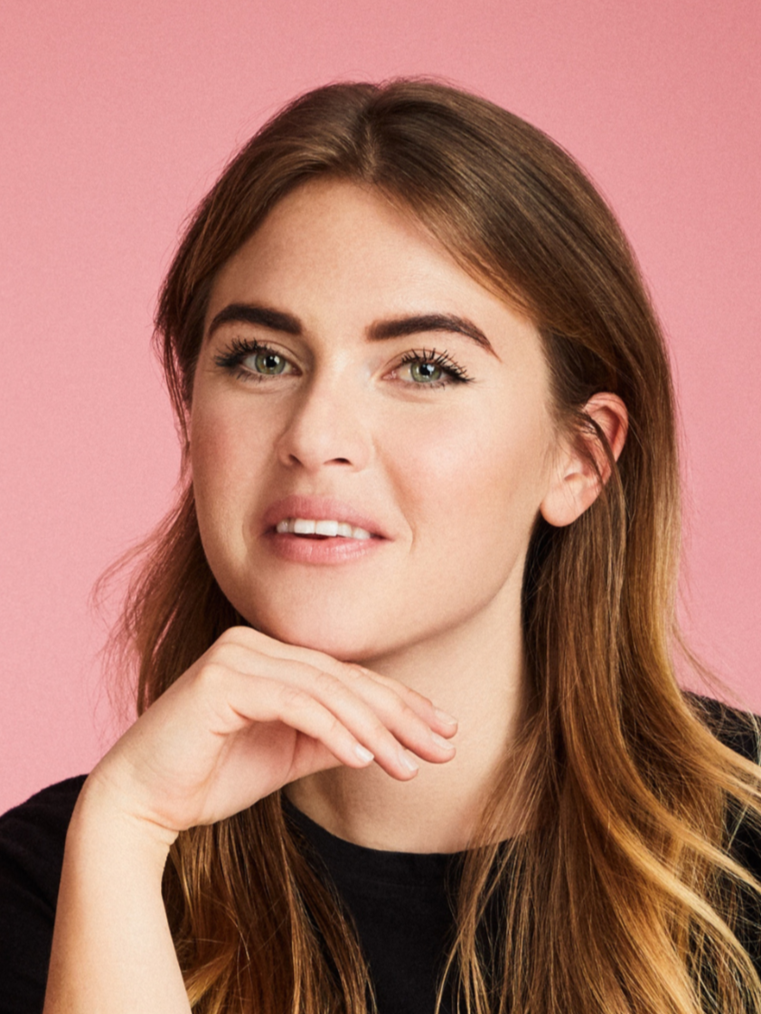 Andrea Nerep, Founder and Head of Brand and Business Development at The Petzbe Agency, in a studio portrait with a pink background.
