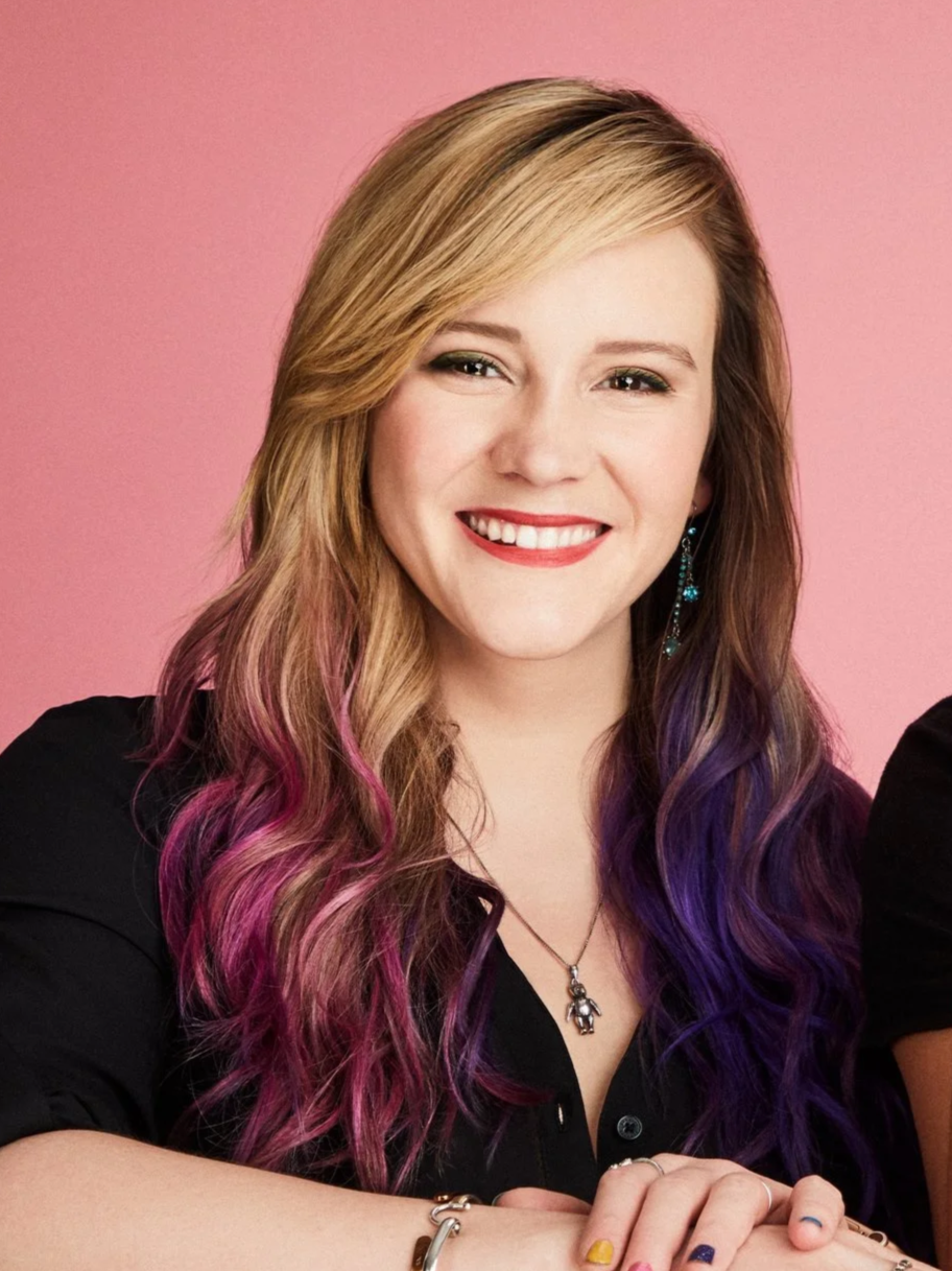Chelsea Rose Riggs, Co-Founder and Head of Social Media and Performance Marketing at The Petzbe Agency, in a studio portrait with a pink background.