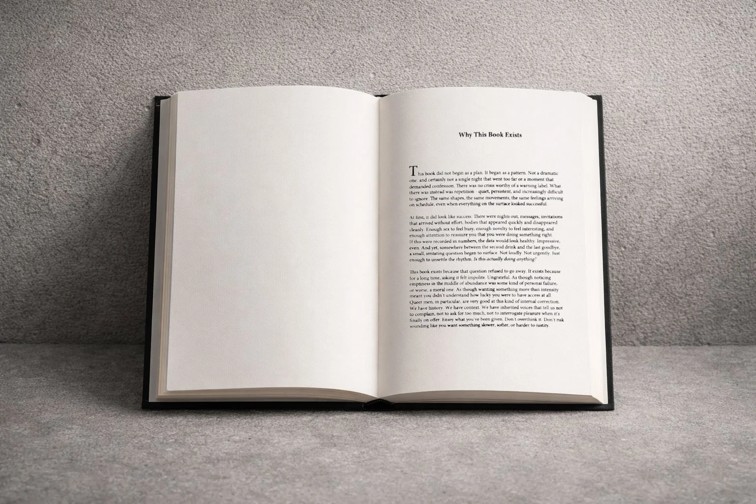 Open book on a grey surface showing a chapter titled 'Why This Book Exists' with printed text on the right-hand page.