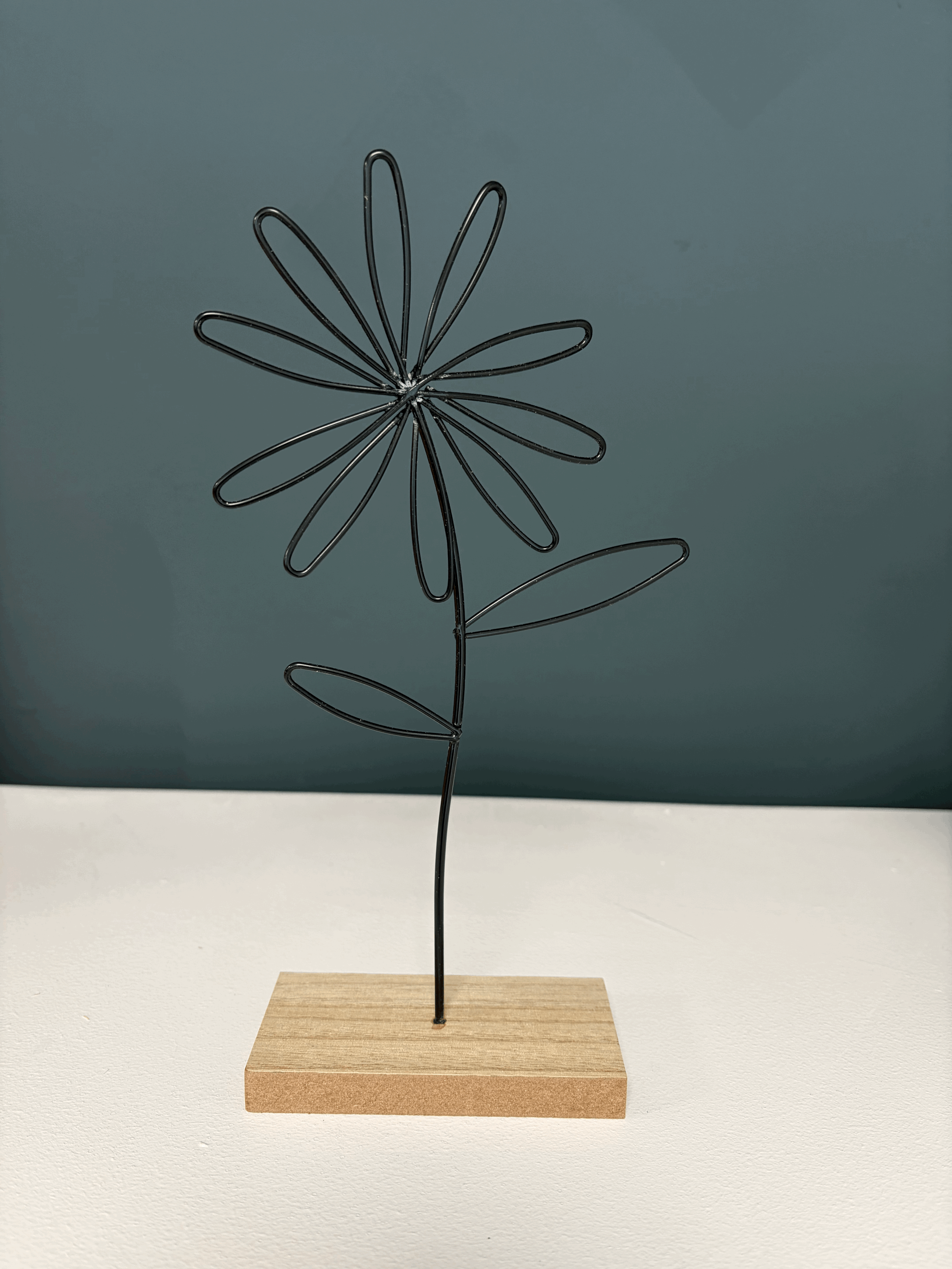Metal flower stem on wooden base