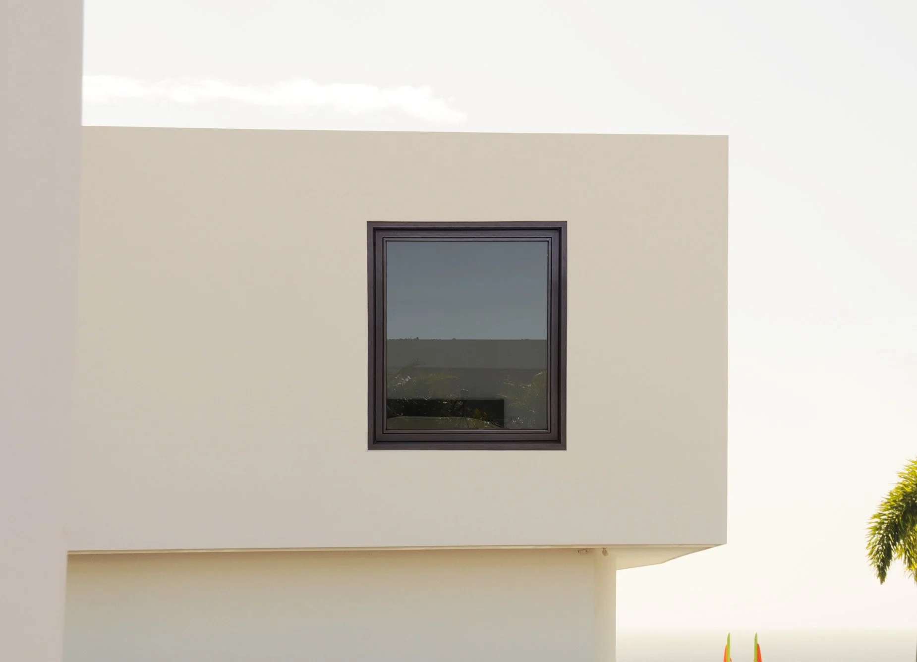Ventana rectangular en una pared blanca, con paisaje y cielo visible a través del vidrio.