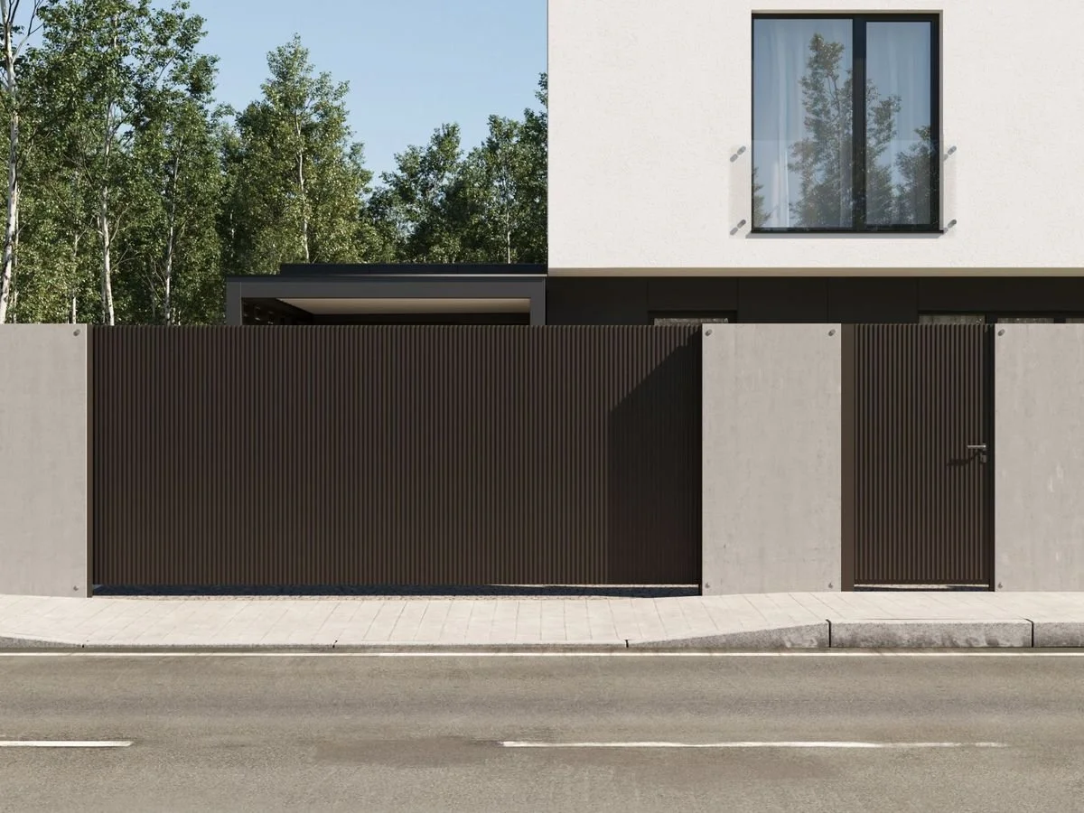 Fachada de una casa moderna con muro y puerta de cerrado de color oscuro.