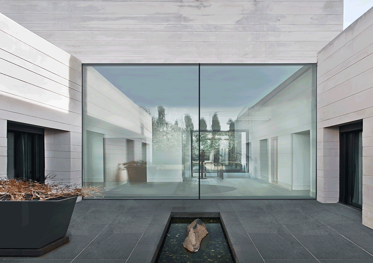 Fachada moderna de casa con pared de vidrio y patio minimalista