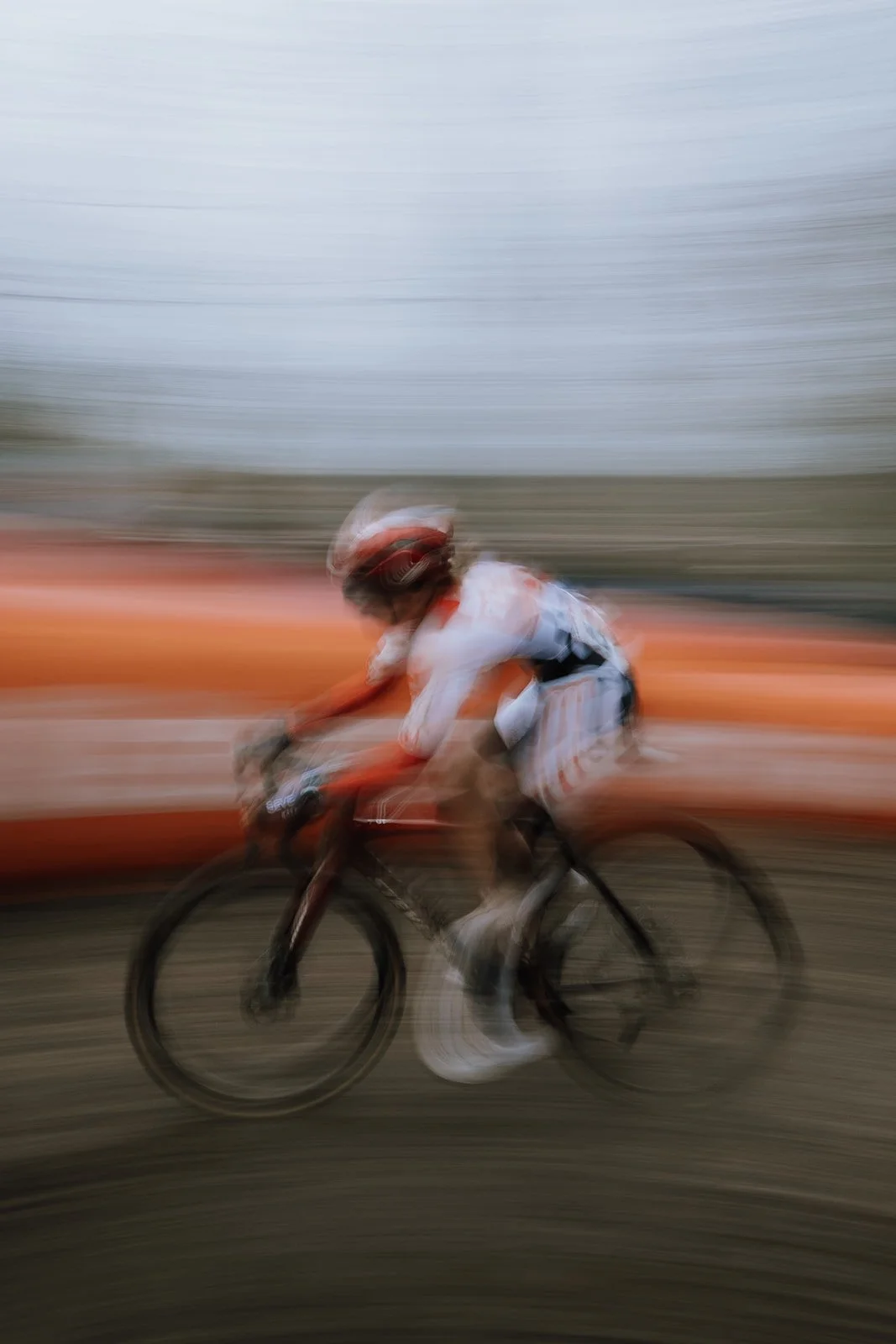 A cyclist wearing a helmet and sportswear riding a bike with motion blur effect.