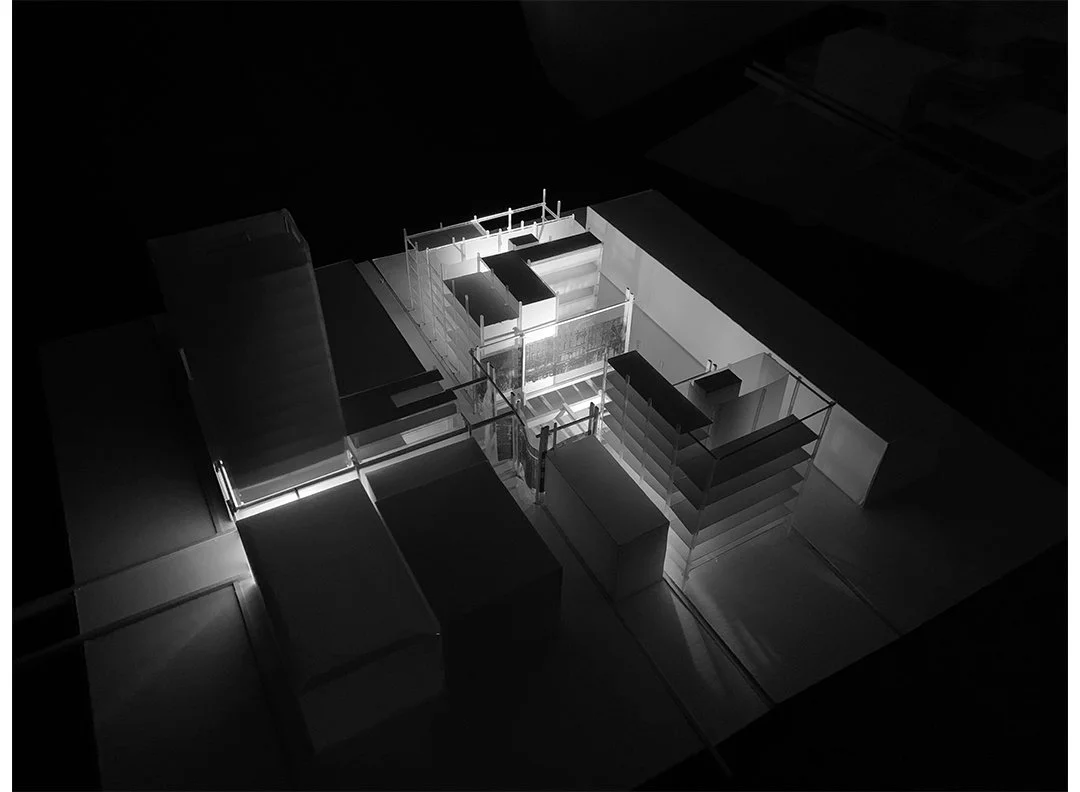 Architectural model of a building illuminated with lighting, viewed from above.