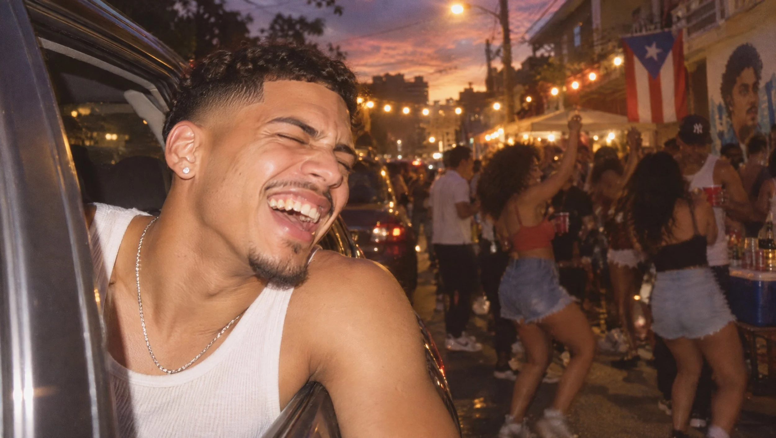 A young man laughing at an evening block party.