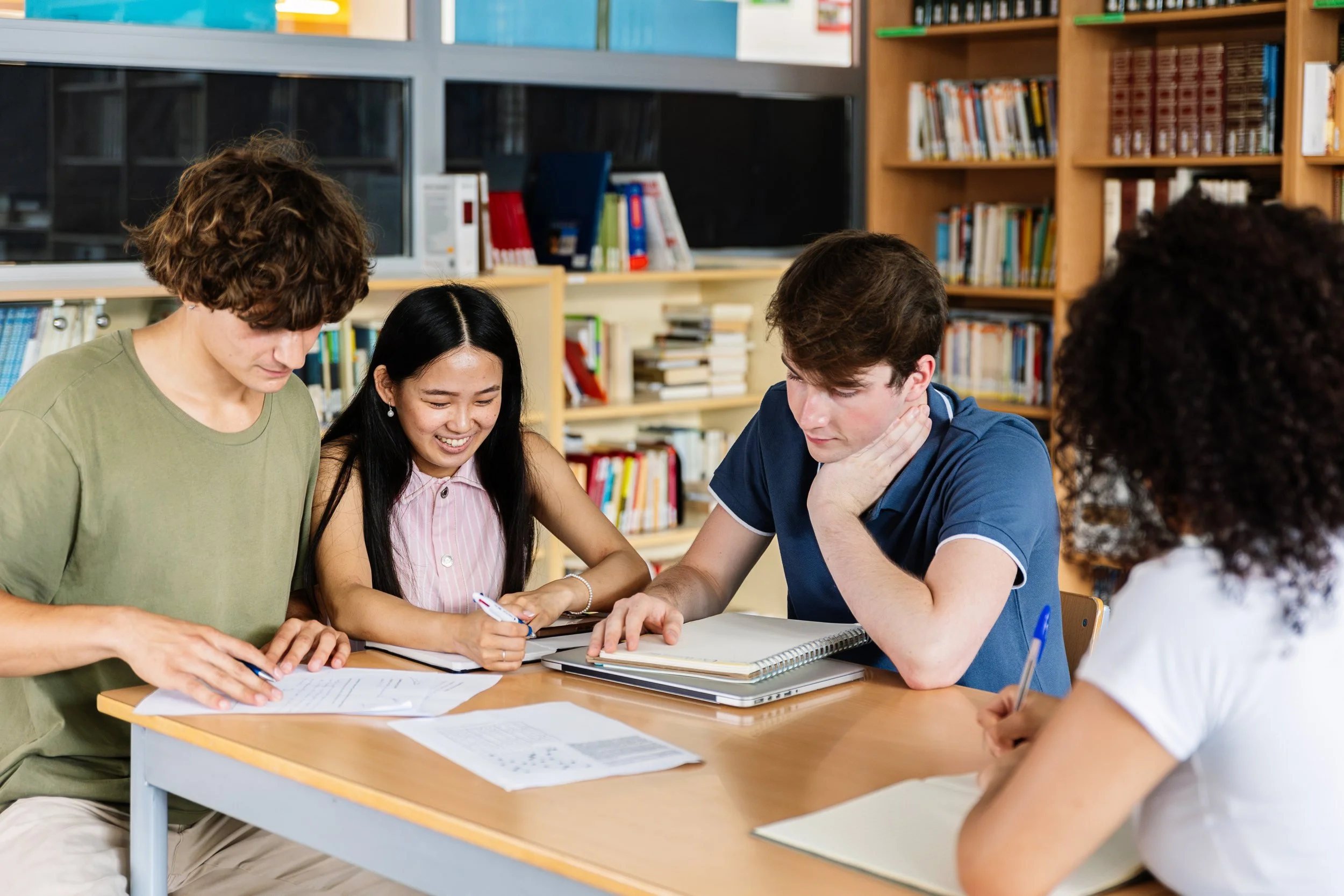 Students reading and writing at a library table