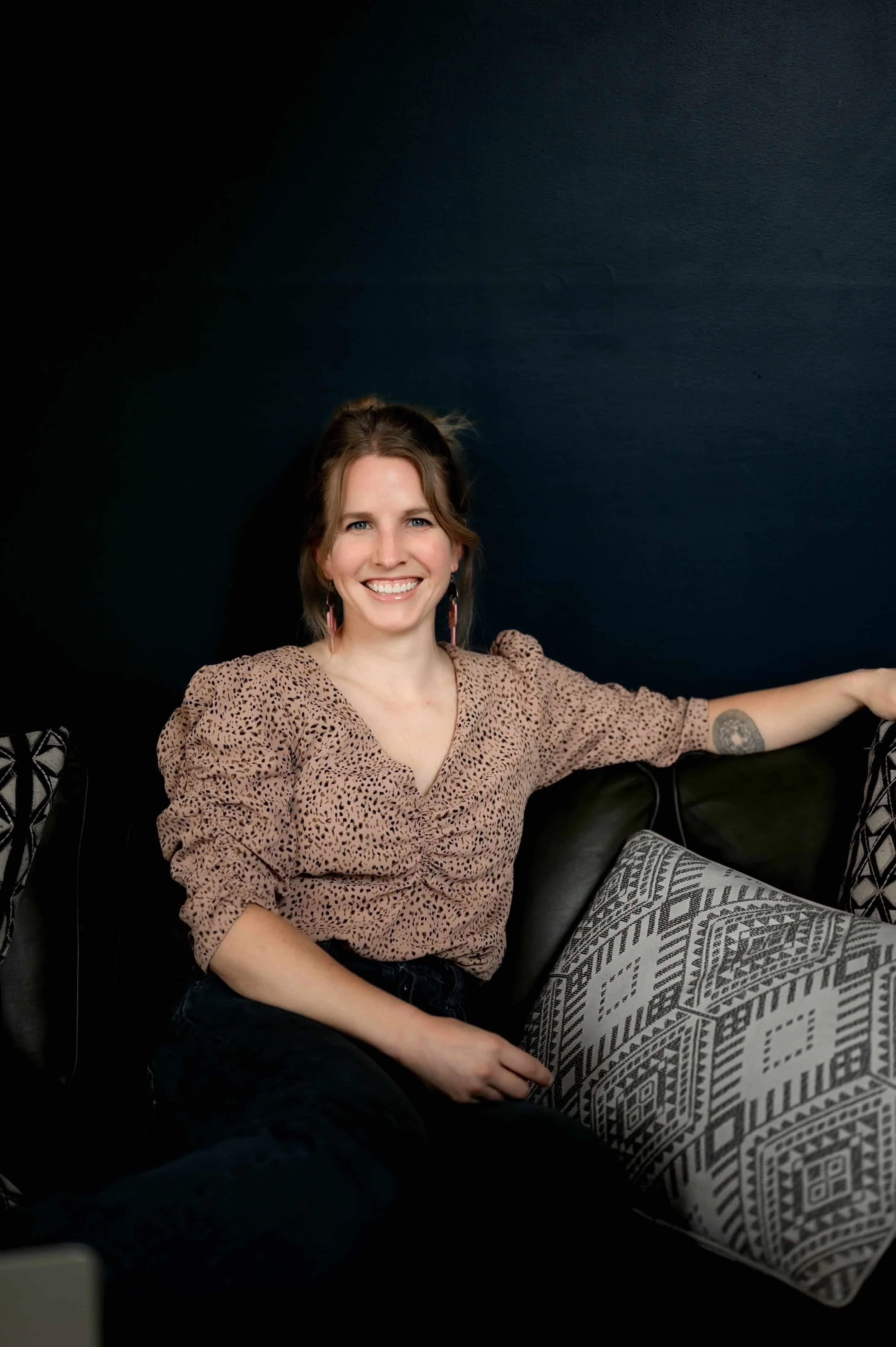 Life, leadership, executive coach smiles at the camera from a welcoming environment.