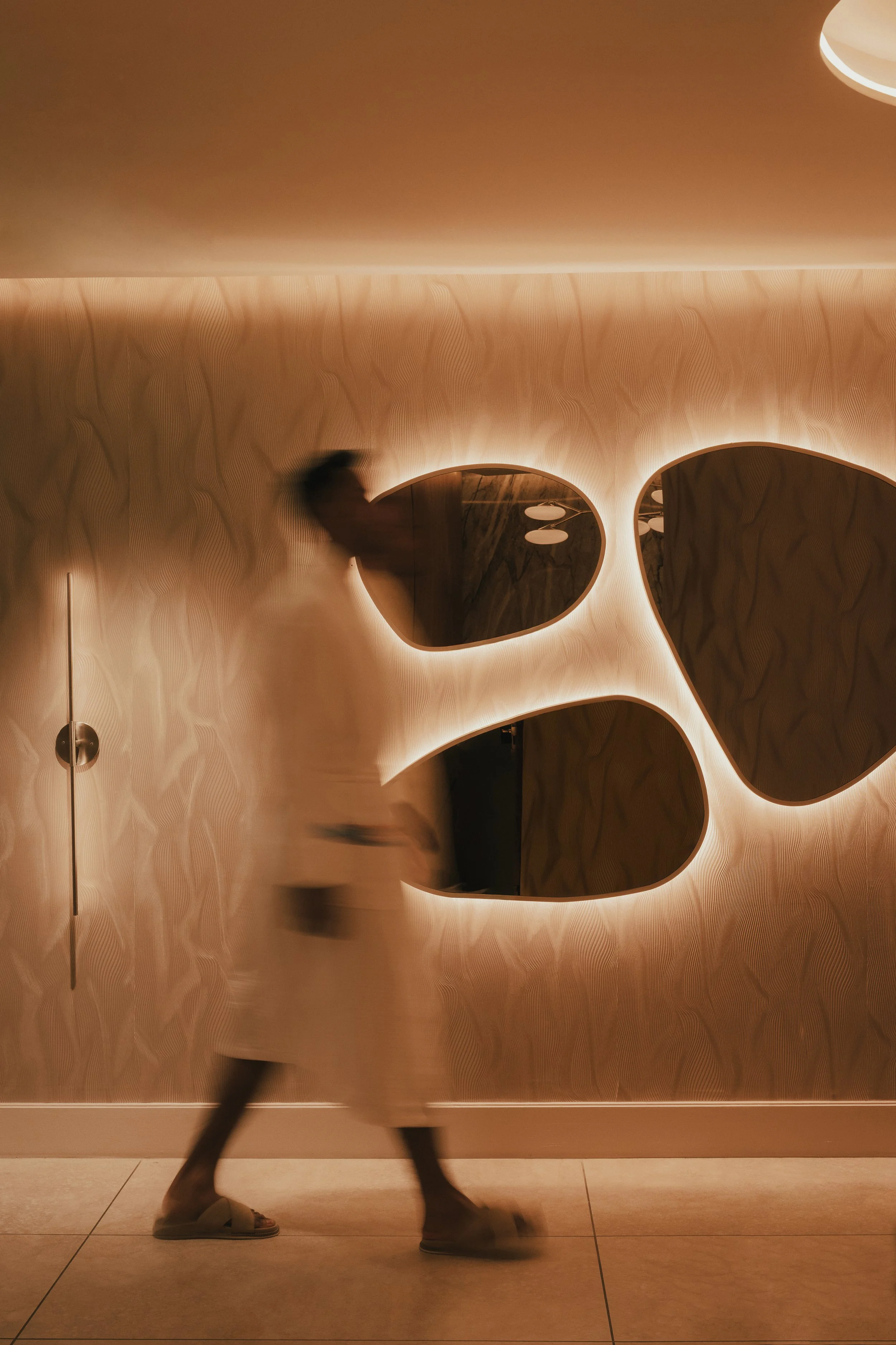 Man Walking by Mirrors in Spa Reception