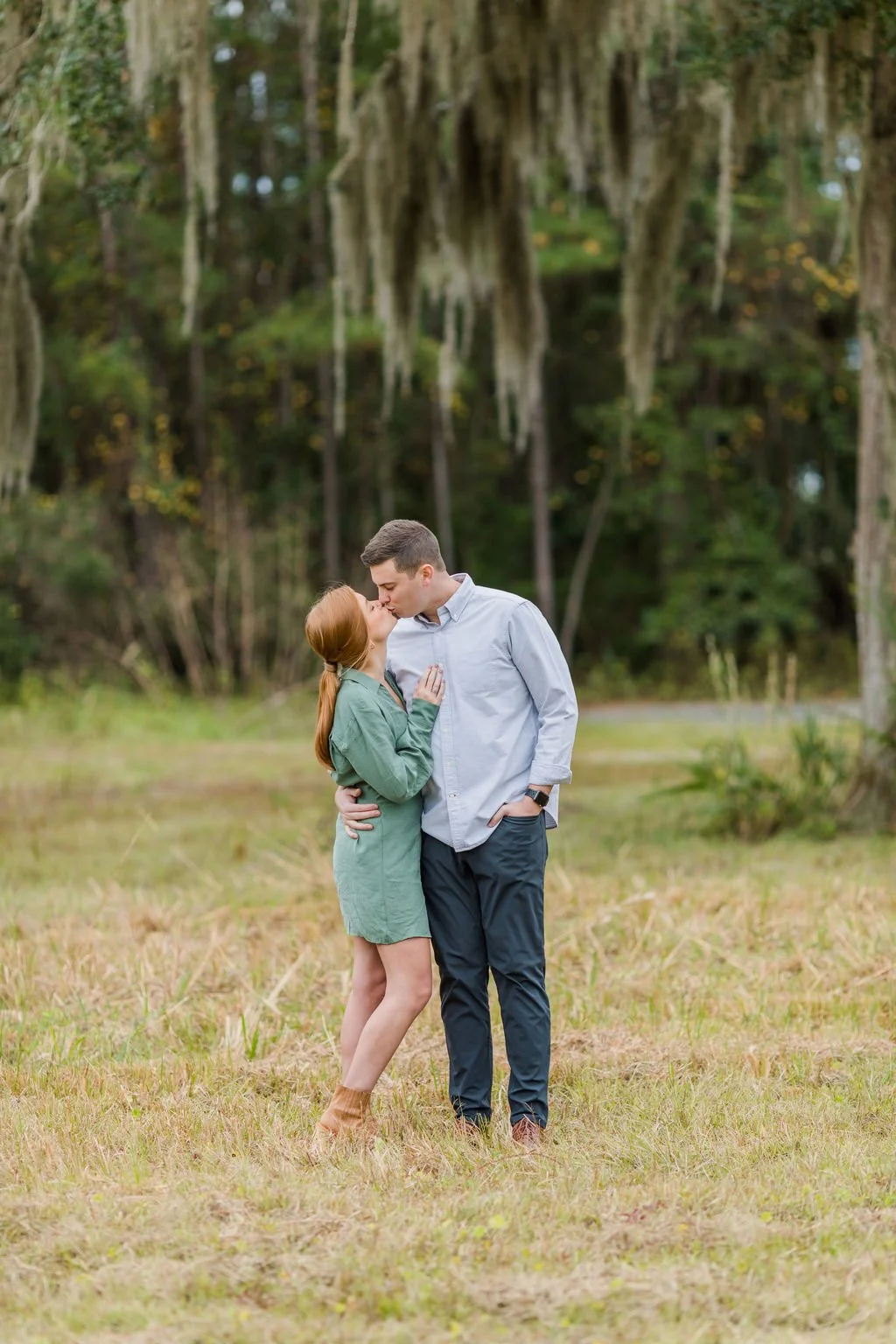 man and woman hugging and kissing under a moss tree on oak grove island