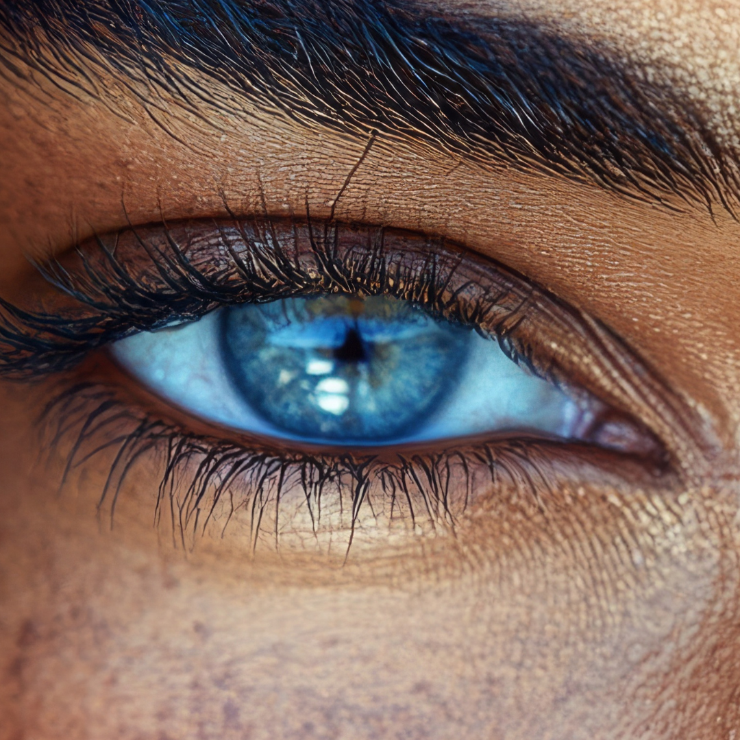 Close-up of a human eye with a blue iris and detailed eyelashes and skin texture.