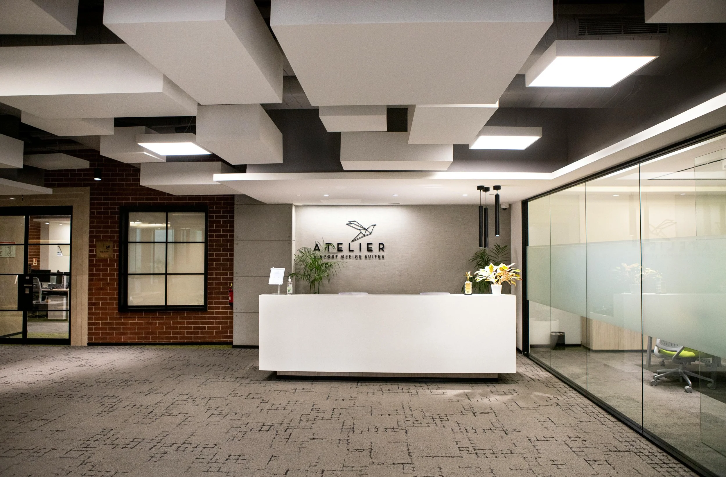Contemporary private office interior with warm wood and glass partitions, showing a bespoke corporate workspace design