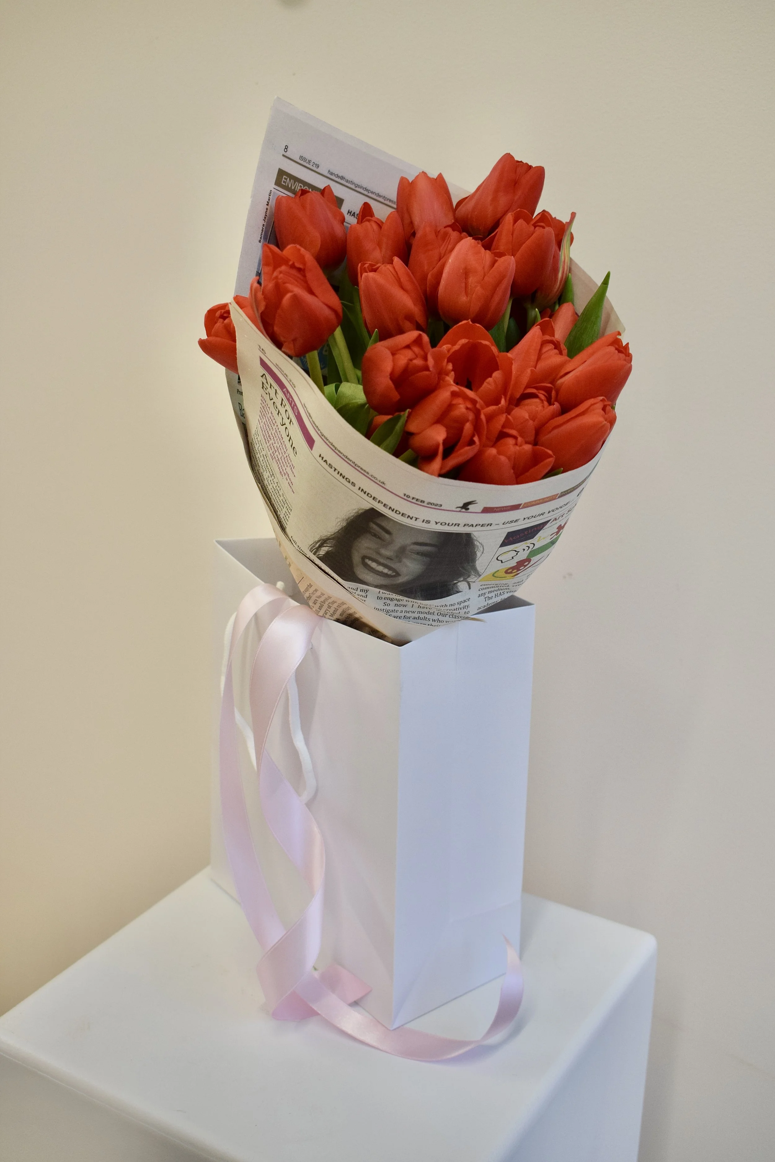 A bouquet of bright red tulips for Valentines Day, wrapped in Hastings Independent newspaper