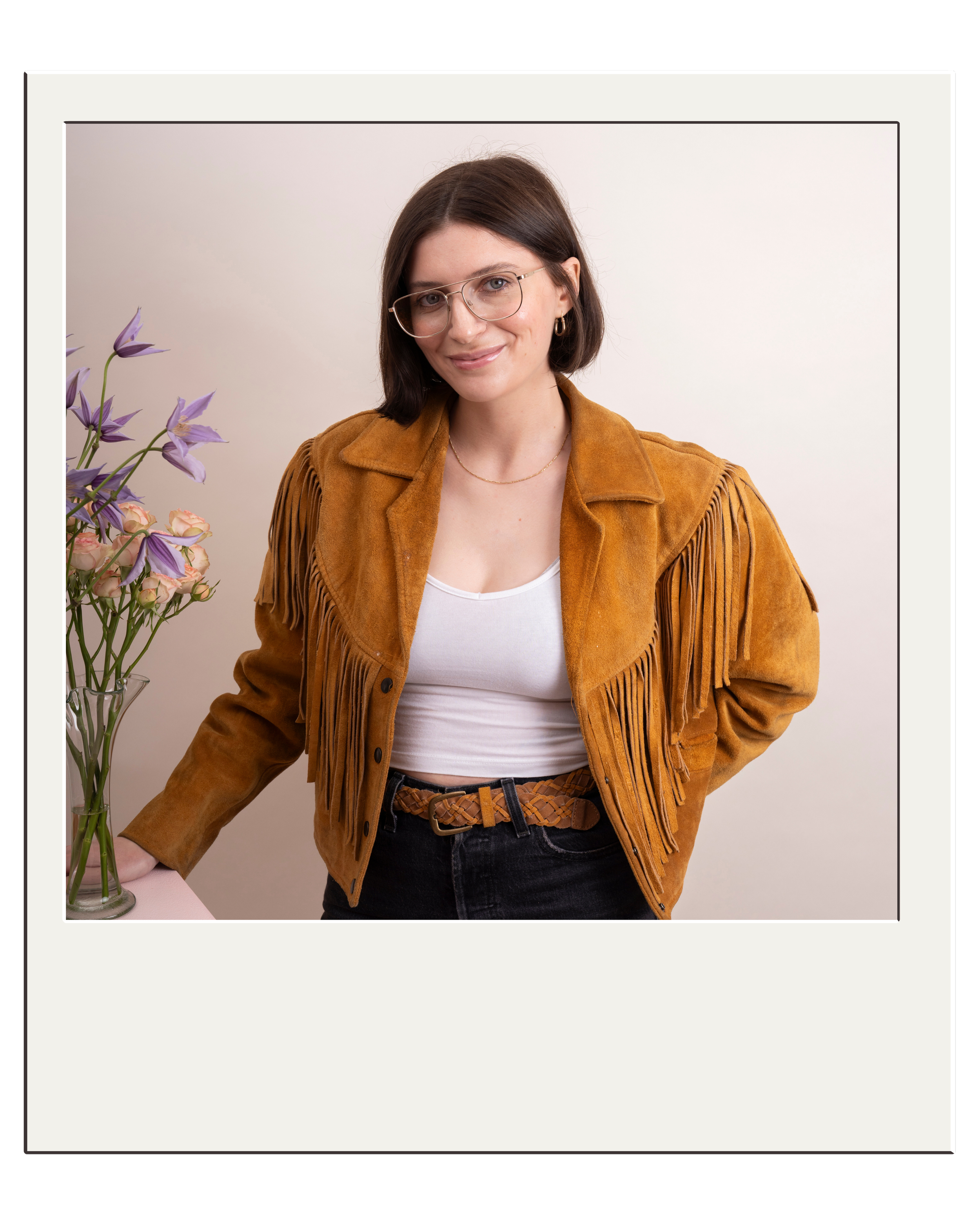 A florist with short brown hair and a vintage suede cowboy jacket on