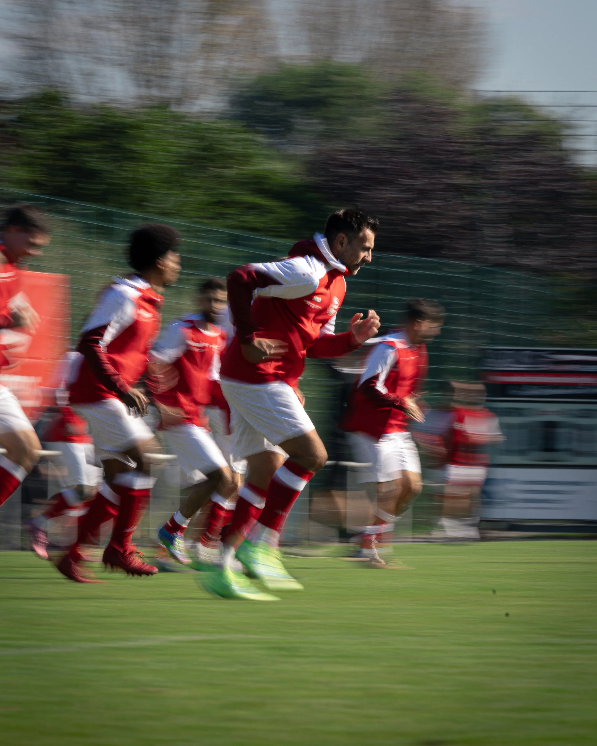 Soccer players running on a field during a match.