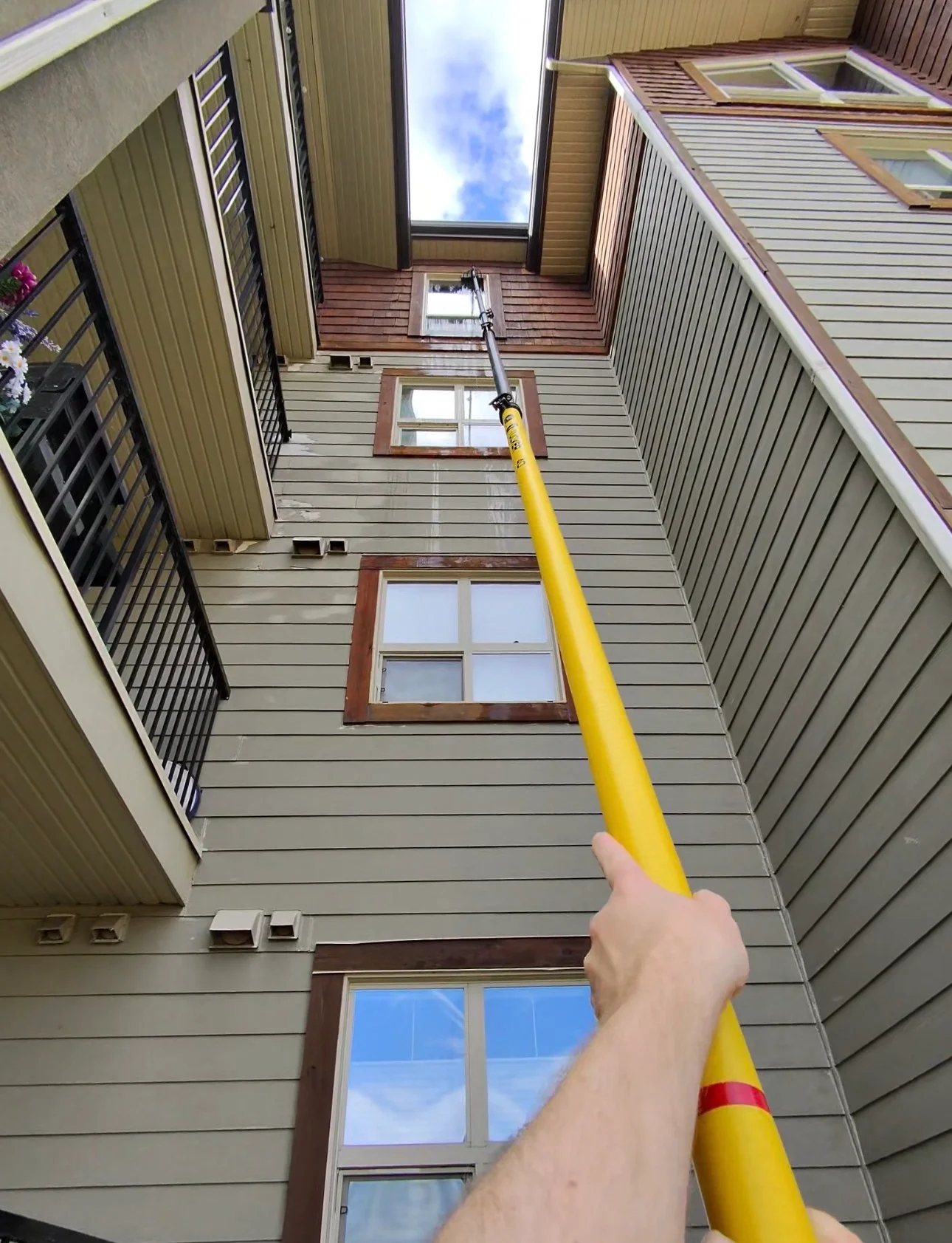 Water-fed pole window cleaning on a multi-storey condo building in the Columbia Valley using ground-based pure water cleaning systems.
