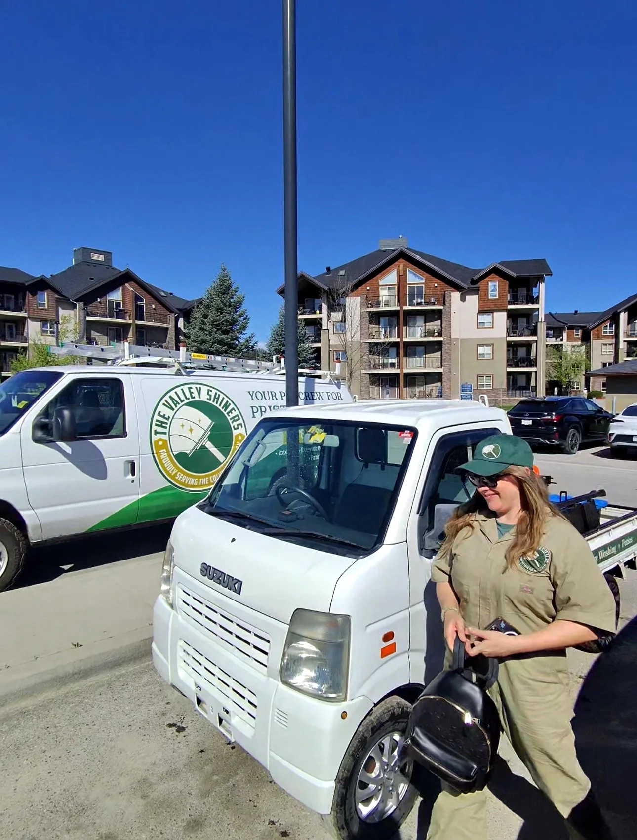 Valley Shiners crew member arriving at a condo development in Invermere for scheduled strata window cleaning and exterior maintenance services.