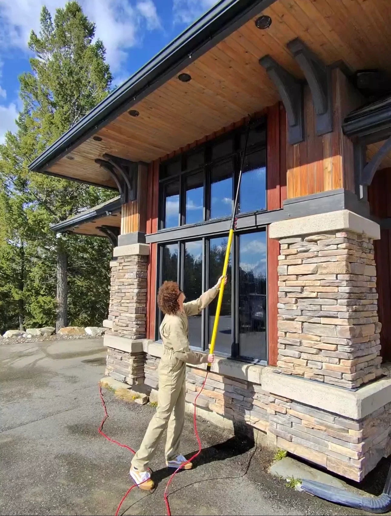 Valley Shiners crew member cleaning exterior windows at Copper Point Golf Course clubhouse in Invermere using a pure water pole system