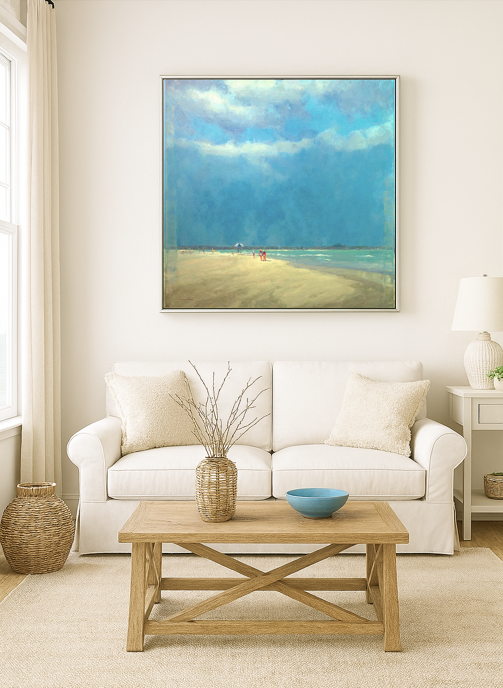 Salty Sea Breezes 36x36 beach painting in silver frame displayed above white sofa in bright coastal living room with natural textures