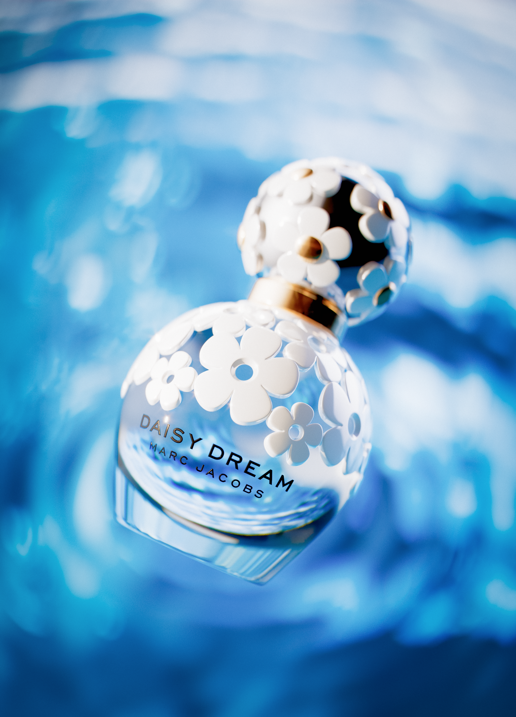 CGI visualization of the Marc Jacobs Daisy Dream fragrance bottle floating over soft blue ripples. The image explores transparency, reflection, and refraction through glass and light, evoking freshness, elegance, and poetic serenity.