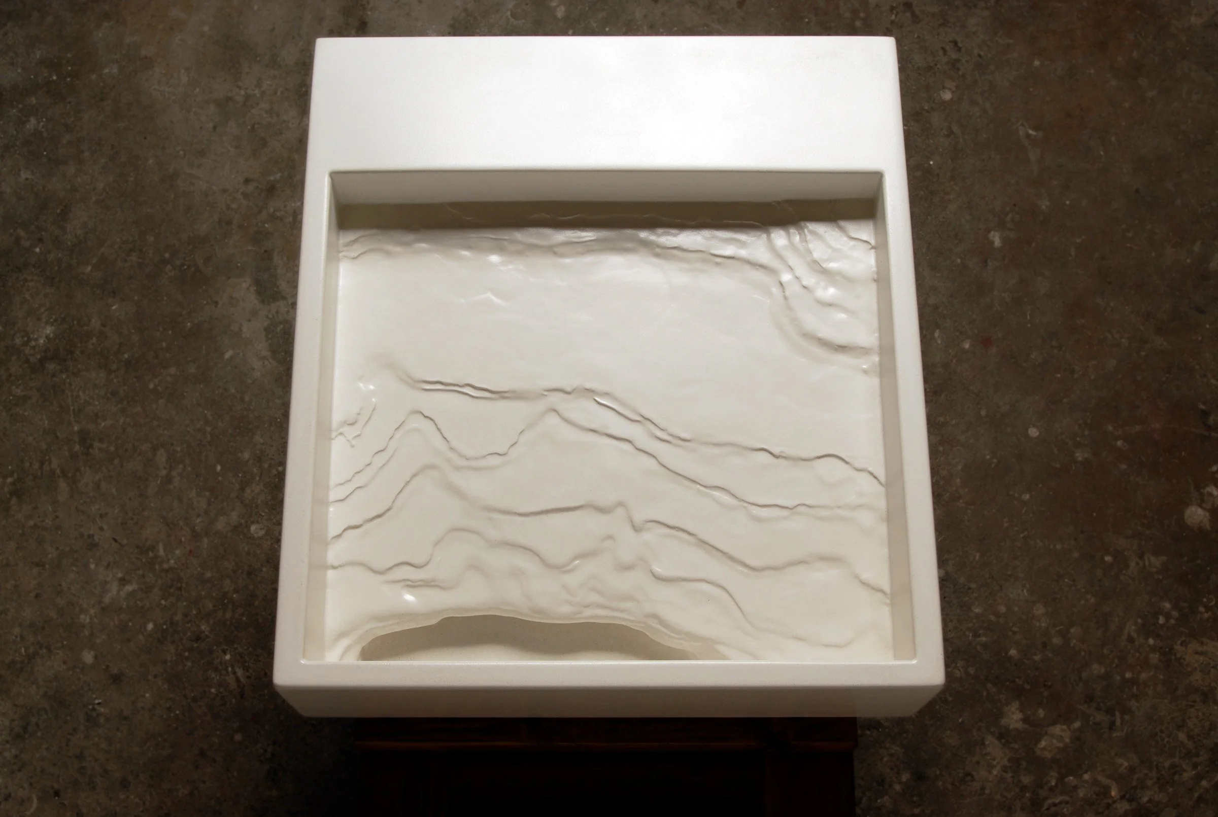 Handcrafted erosion-style concrete sink modeled after a mountain slope.