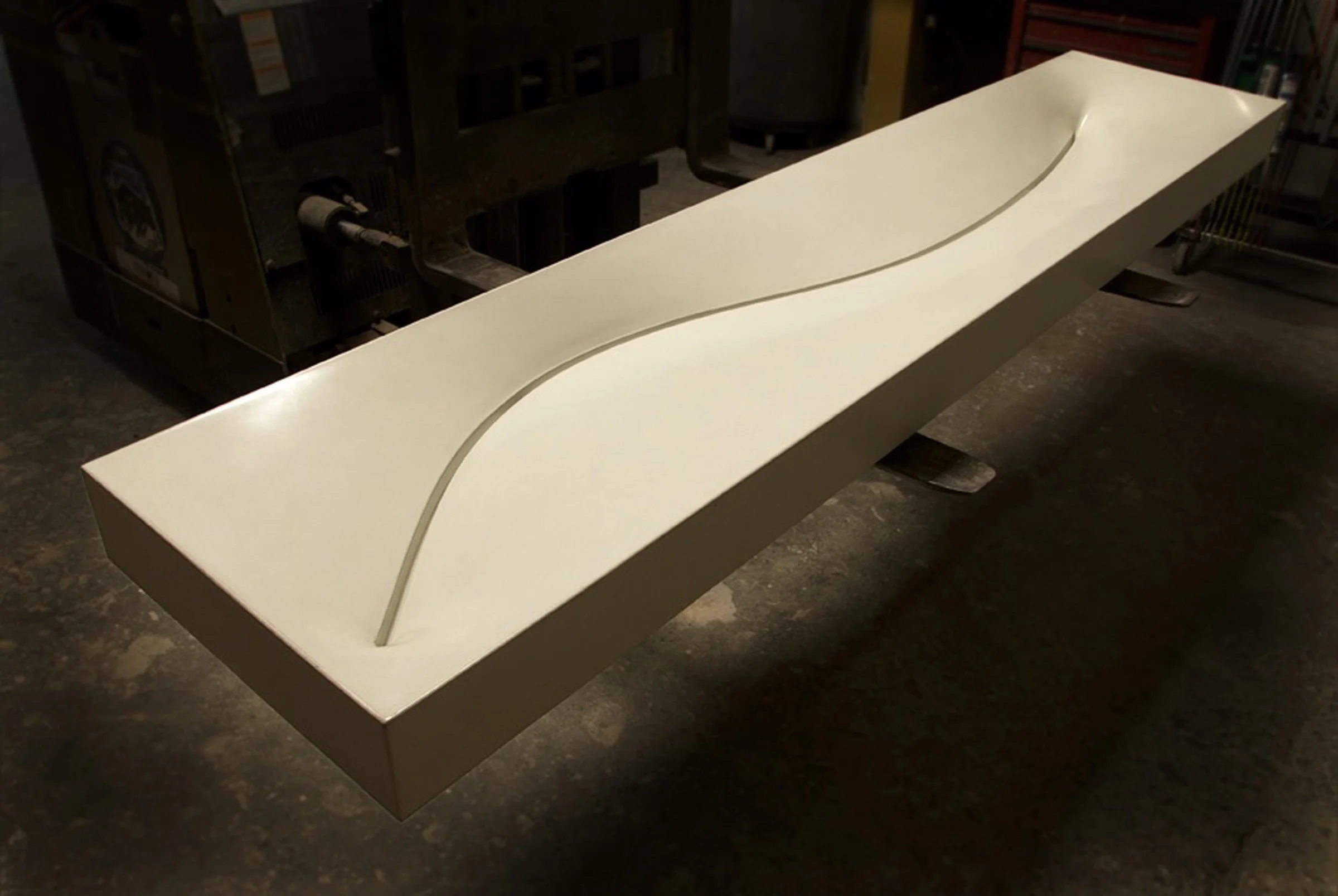 Modern double basin concrete sink with sculptural, fabric-formed contours.