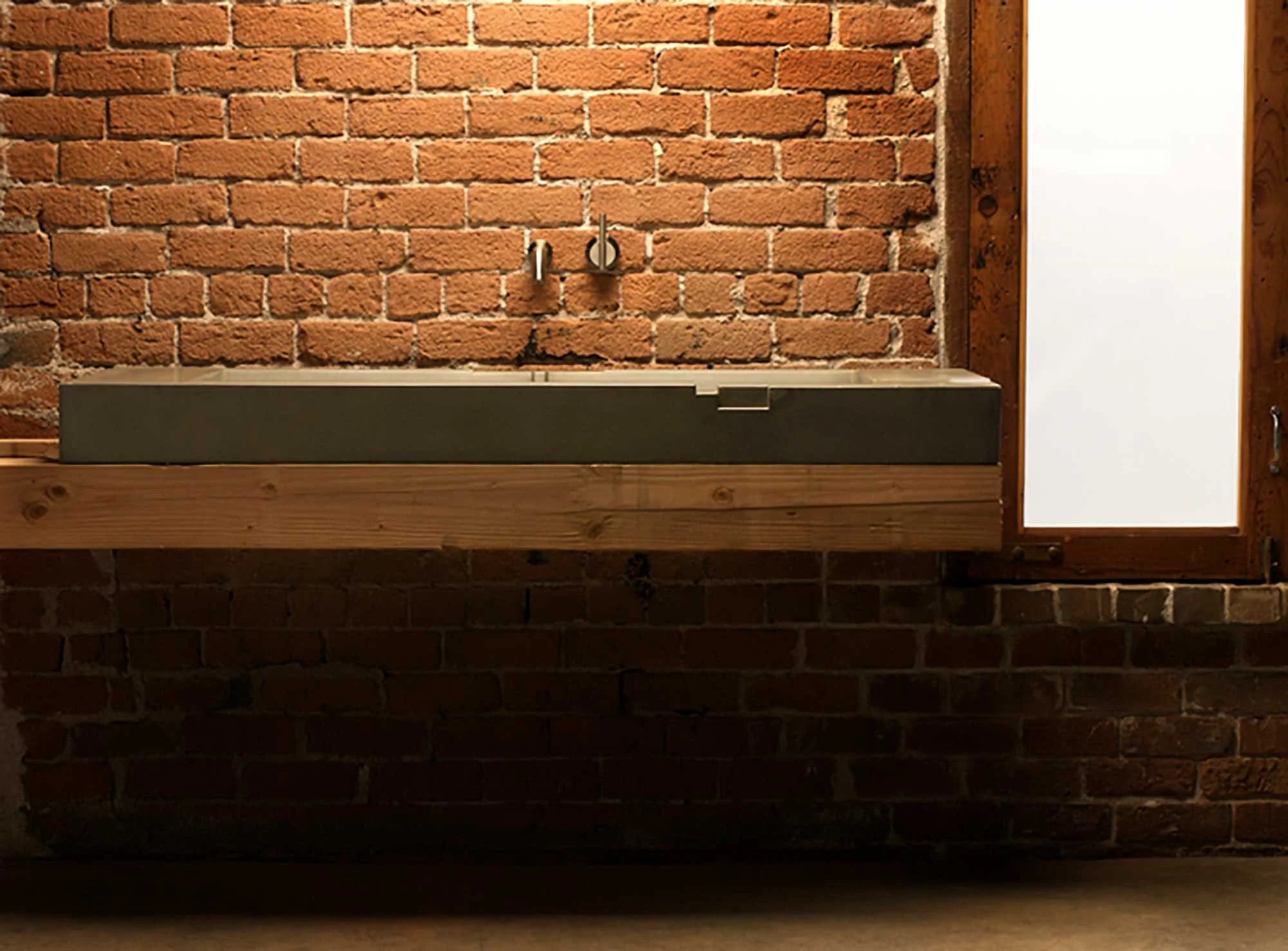 A layered geometric concrete sink reminiscent of Aztec or Mayan pyramids.
