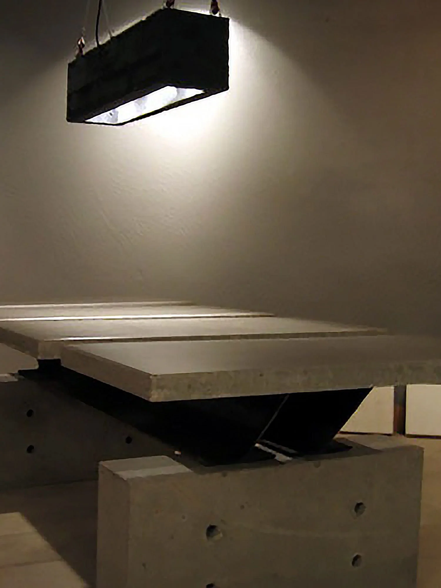 Black concrete light fixture above Bastion conference table.