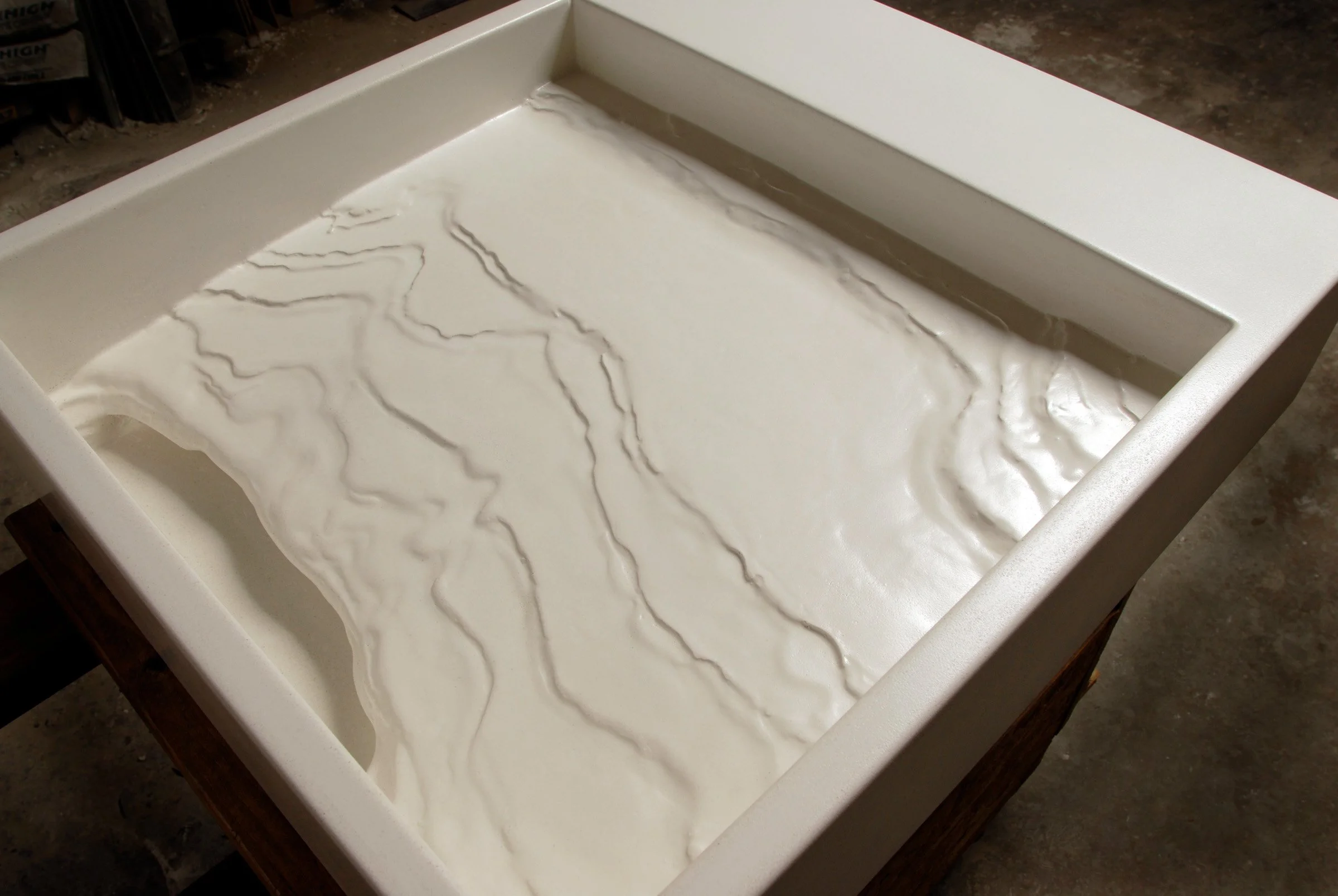 Luxury erosion sink inspired by alpine landscape. Handcrafted in the USA from GFRC concrete with hidden slot drain, designed for modern residential bathrooms.
