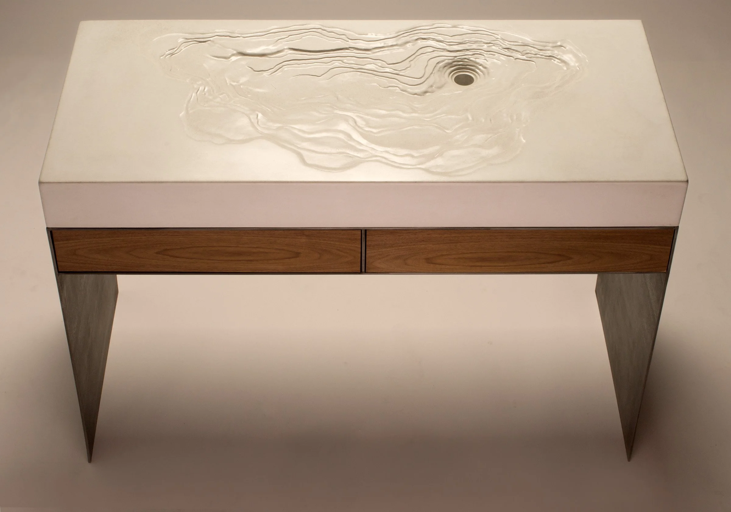 Custom erosion-style topographic sink designed for Dwell on Design. Handcrafted GFRC concrete basin with waxed steel base and rosewood drawers, built for modern luxury bathrooms.