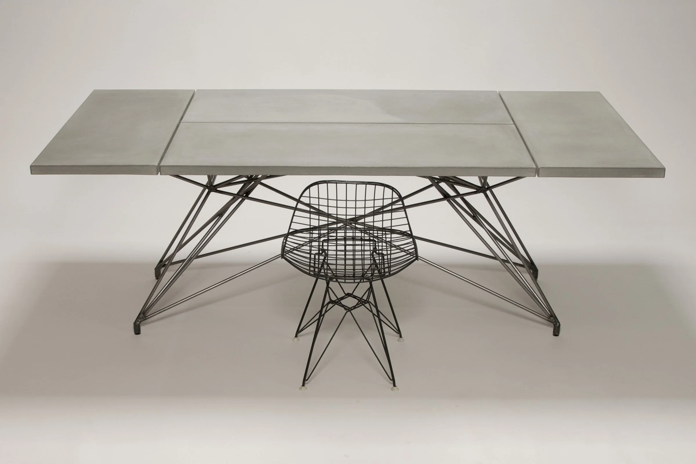 Custom concrete and steel communal dining table for a Phoenix coffee shop. Four-slab design solved social spacing issues while offering durability and style.