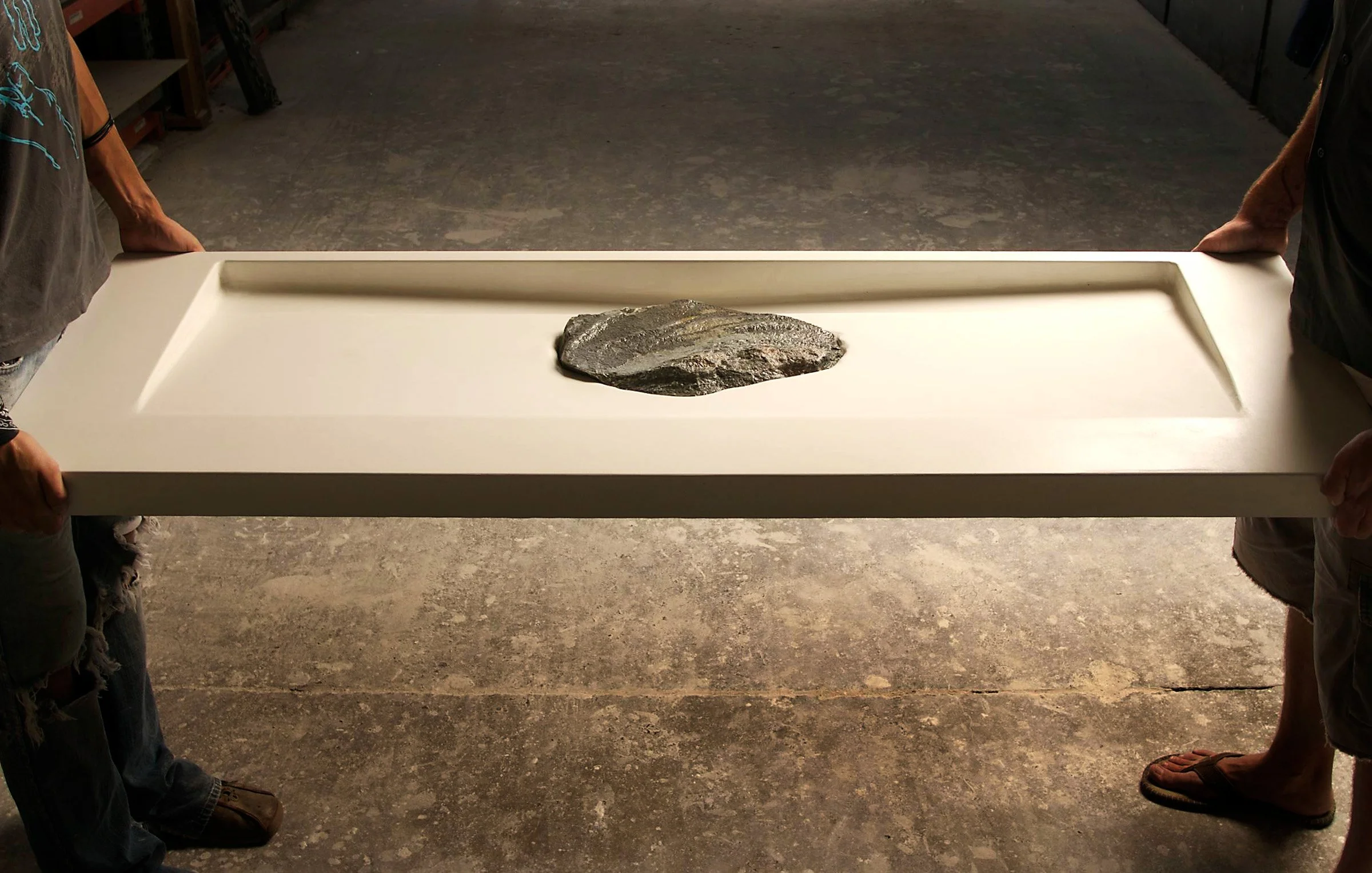 Custom artisan ramp sink with integrated stone detail. Handcrafted GFRC concrete sink designed for residential projects with personal and functional storytelling.