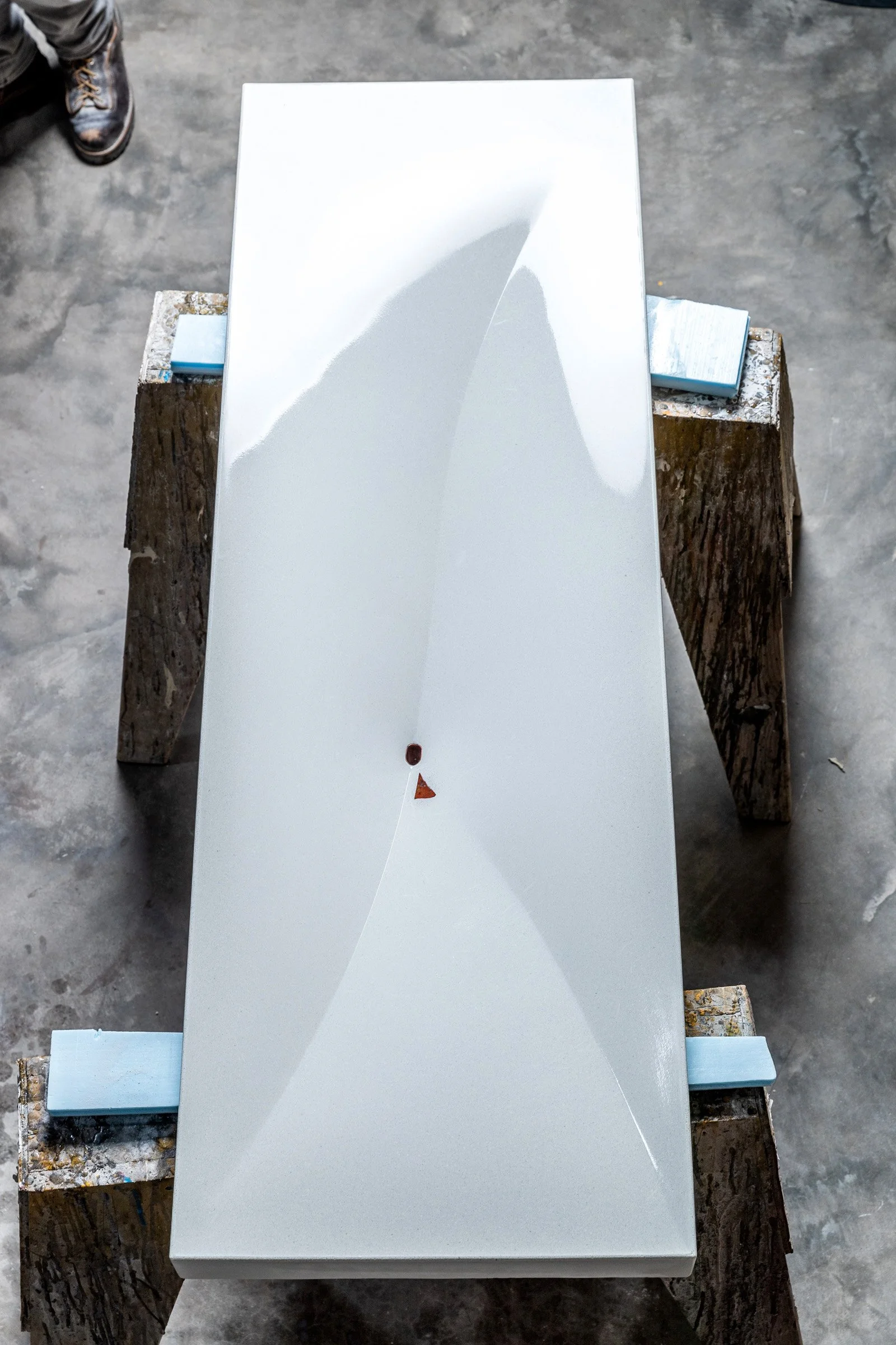 Fabric-formed bathroom sink with unique copper drain and handcrafted finish.