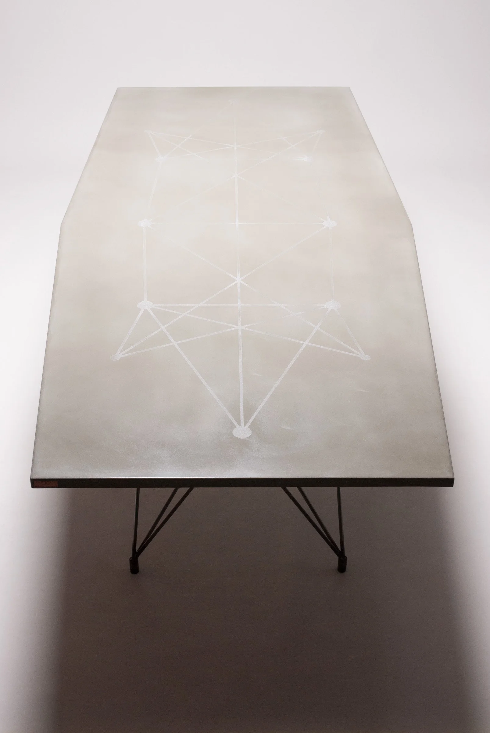 Artisan concrete dining table with etched detail aligned to base structure