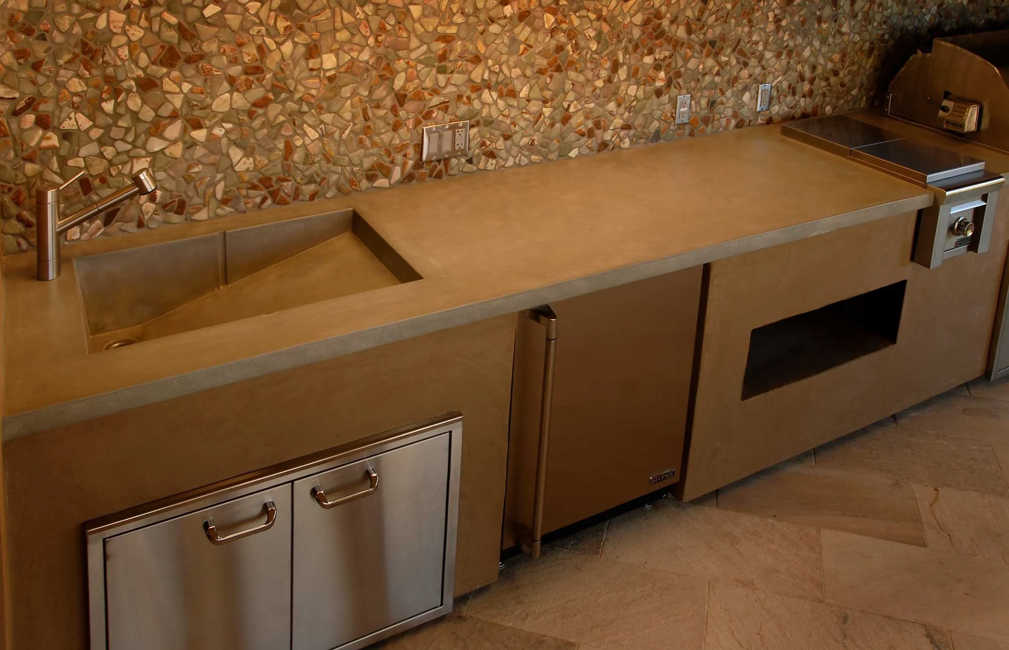 Luxury outdoor concrete BBQ sink with integral divider for cold drinks and washing. Handcrafted in the USA with tea wash finish, built for functional outdoor kitchens.