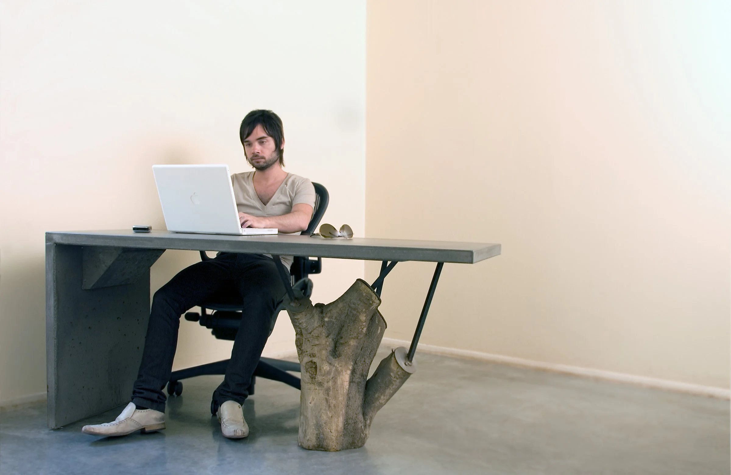Custom concrete desk with steel prosthetics and reclaimed Palo Verde tree base. A functional design piece blending concrete, wood, and desert storytelling.