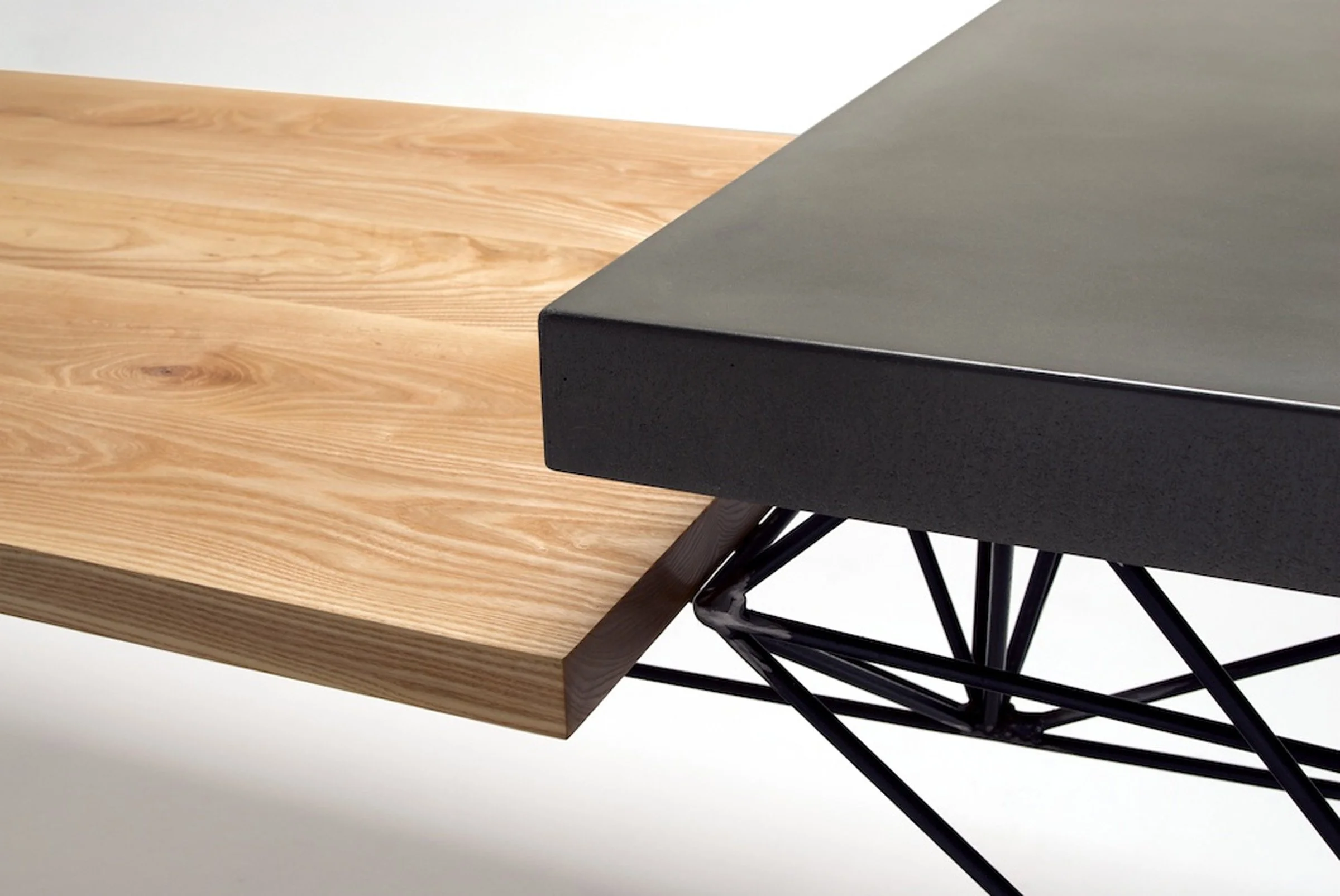 Custom dining furniture pairing concrete, steel, and Eames chairs