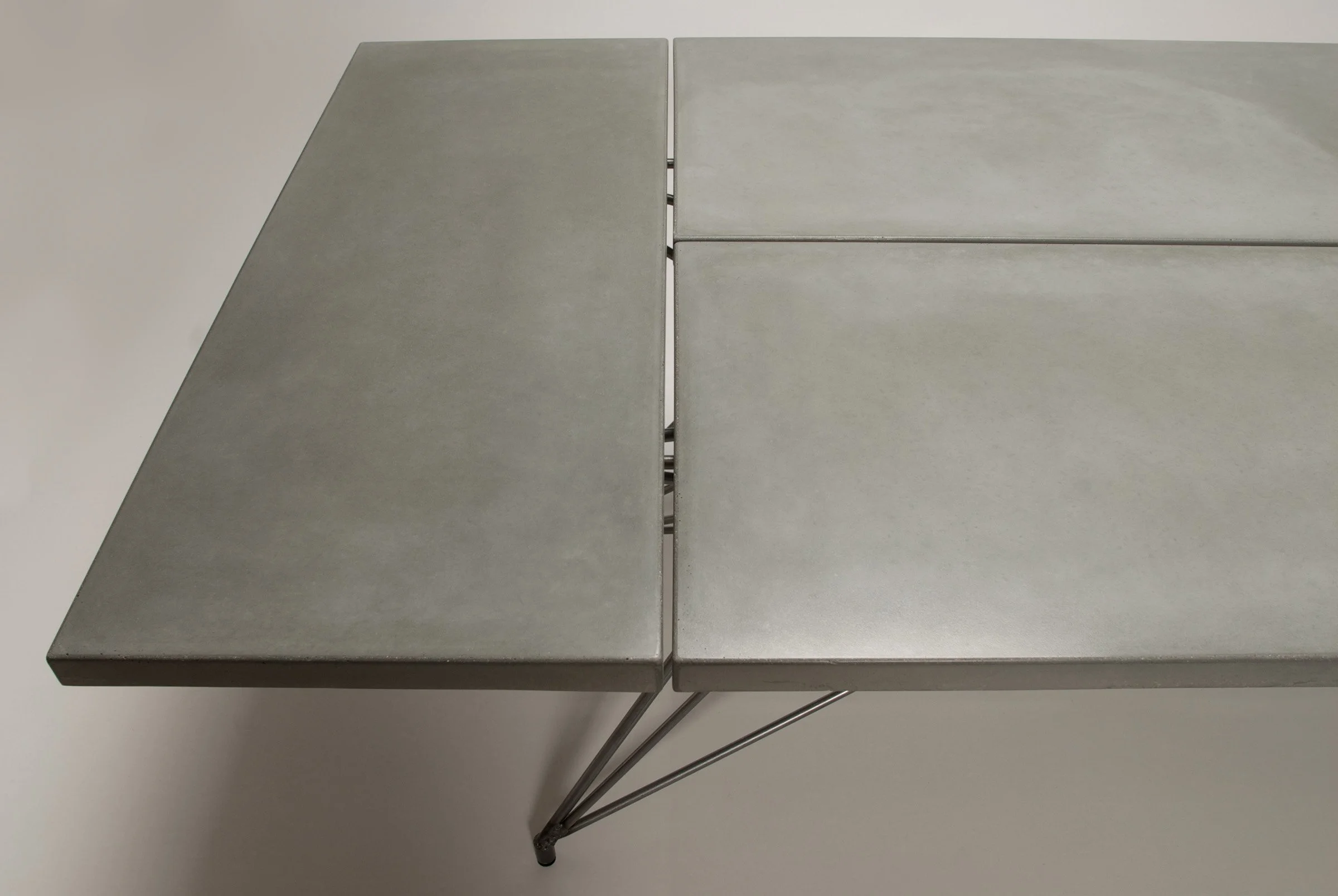 Slate-colored concrete tabletop sections with small gaps for diner comfort