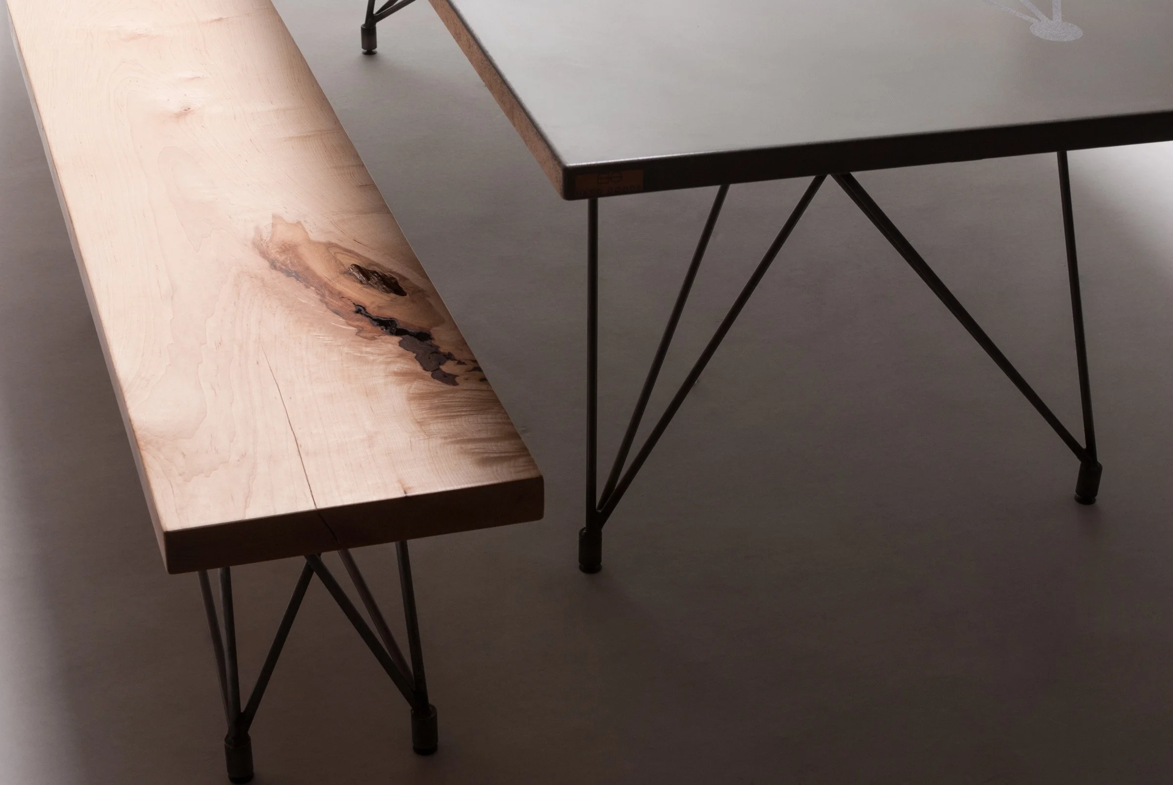 Modern concrete dining table set with custom benches featuring wood seats and steel frames