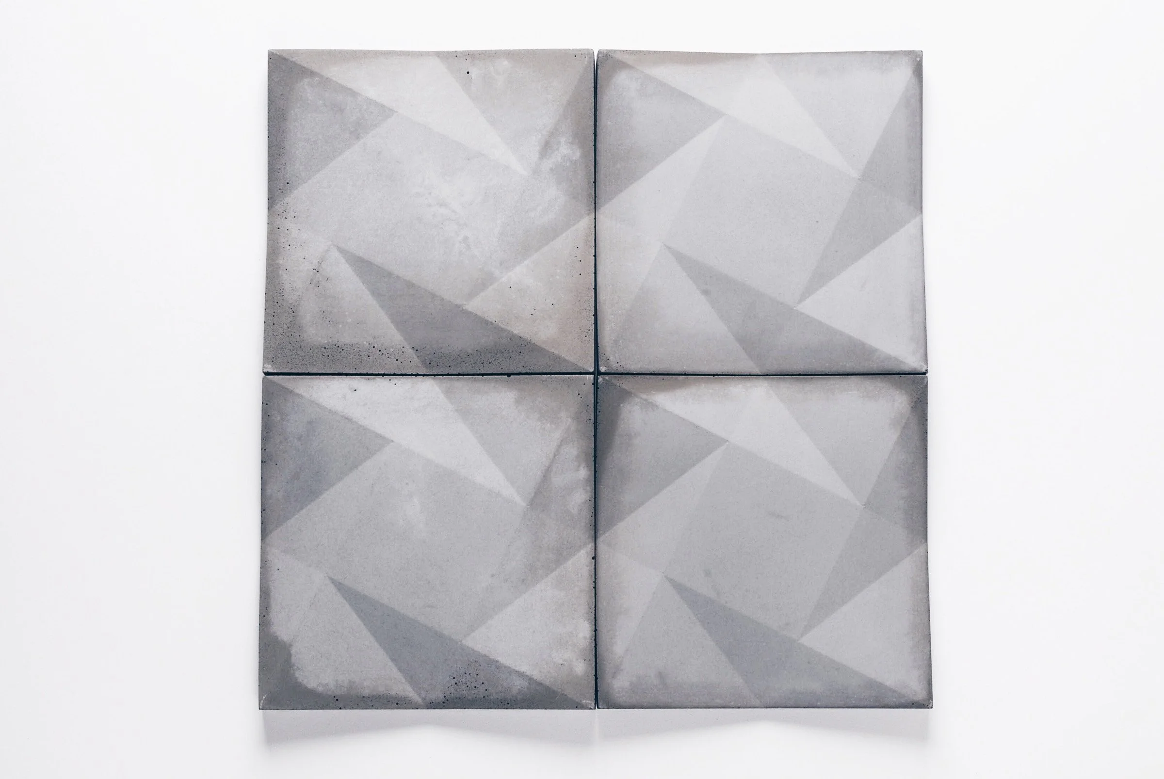Custom concrete wall tile with three-dimensional geometric motif