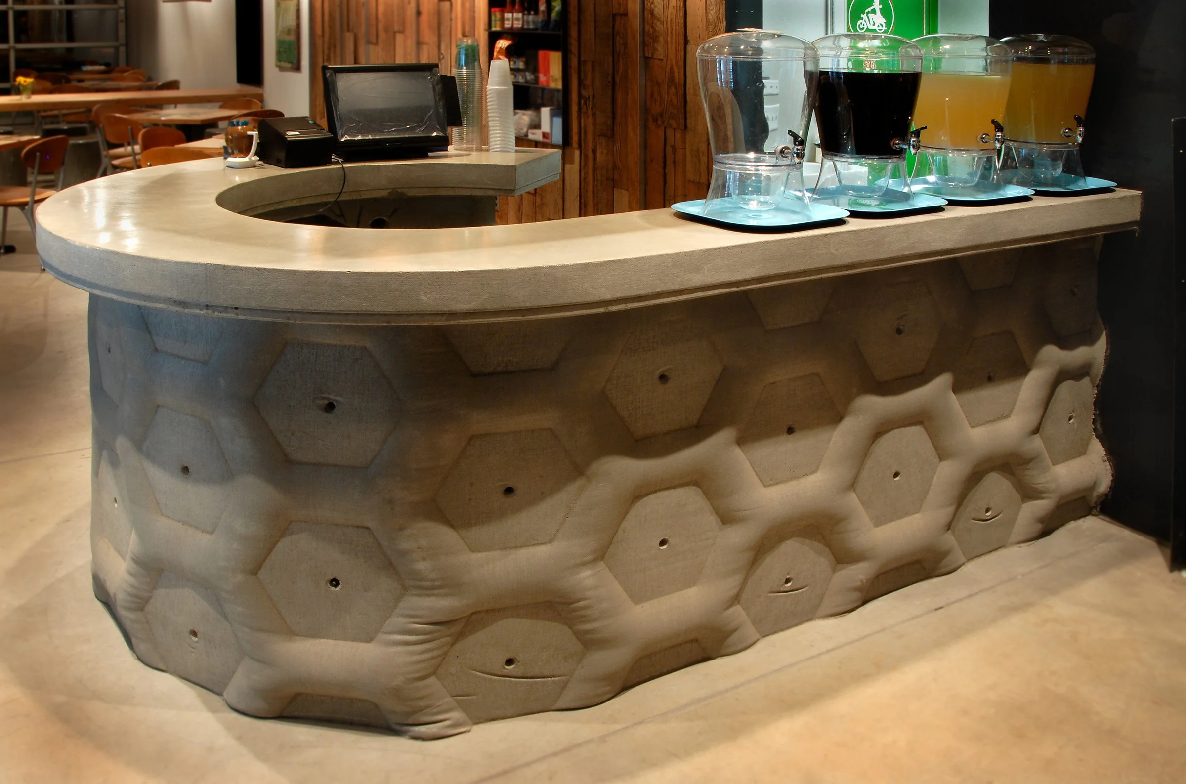 Fabric-formed concrete wall and countertop with hexagon motif. Durable, handcrafted concrete project made with food-safe, healthy finishes for commercial restaurants.