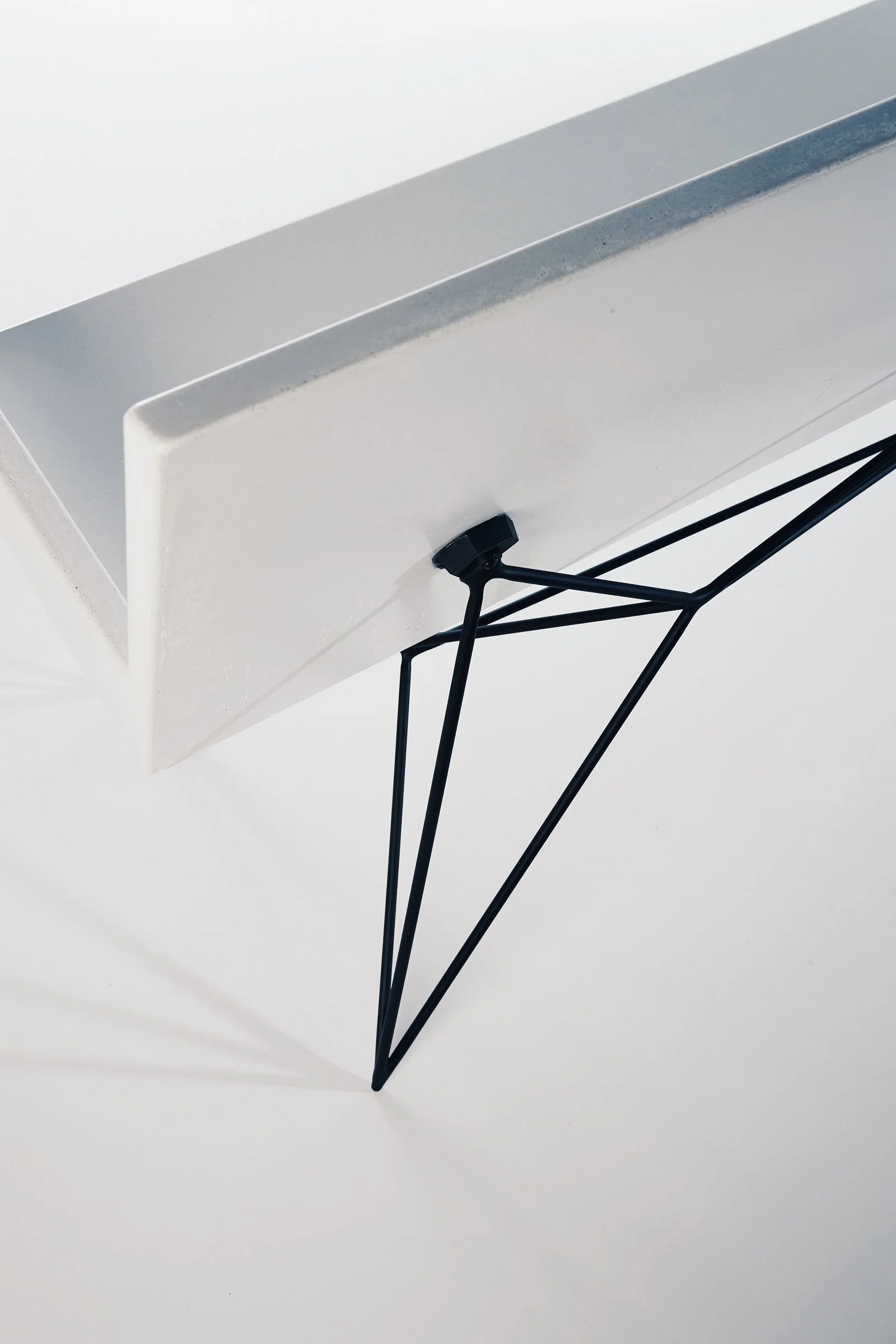 Minimalist white concrete bench with black steel frame and clean lines