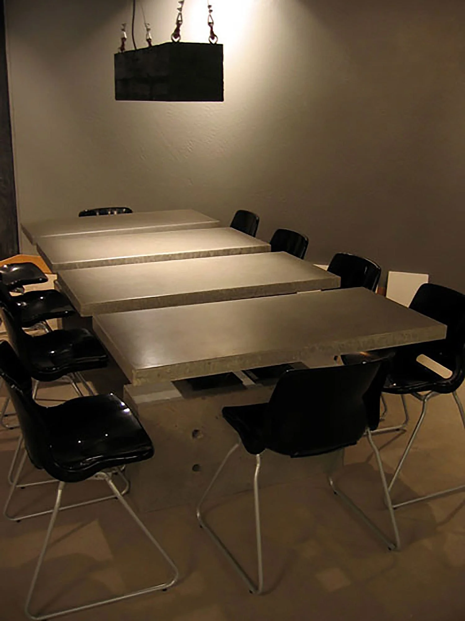 Handcrafted conference table with four slab concrete top.