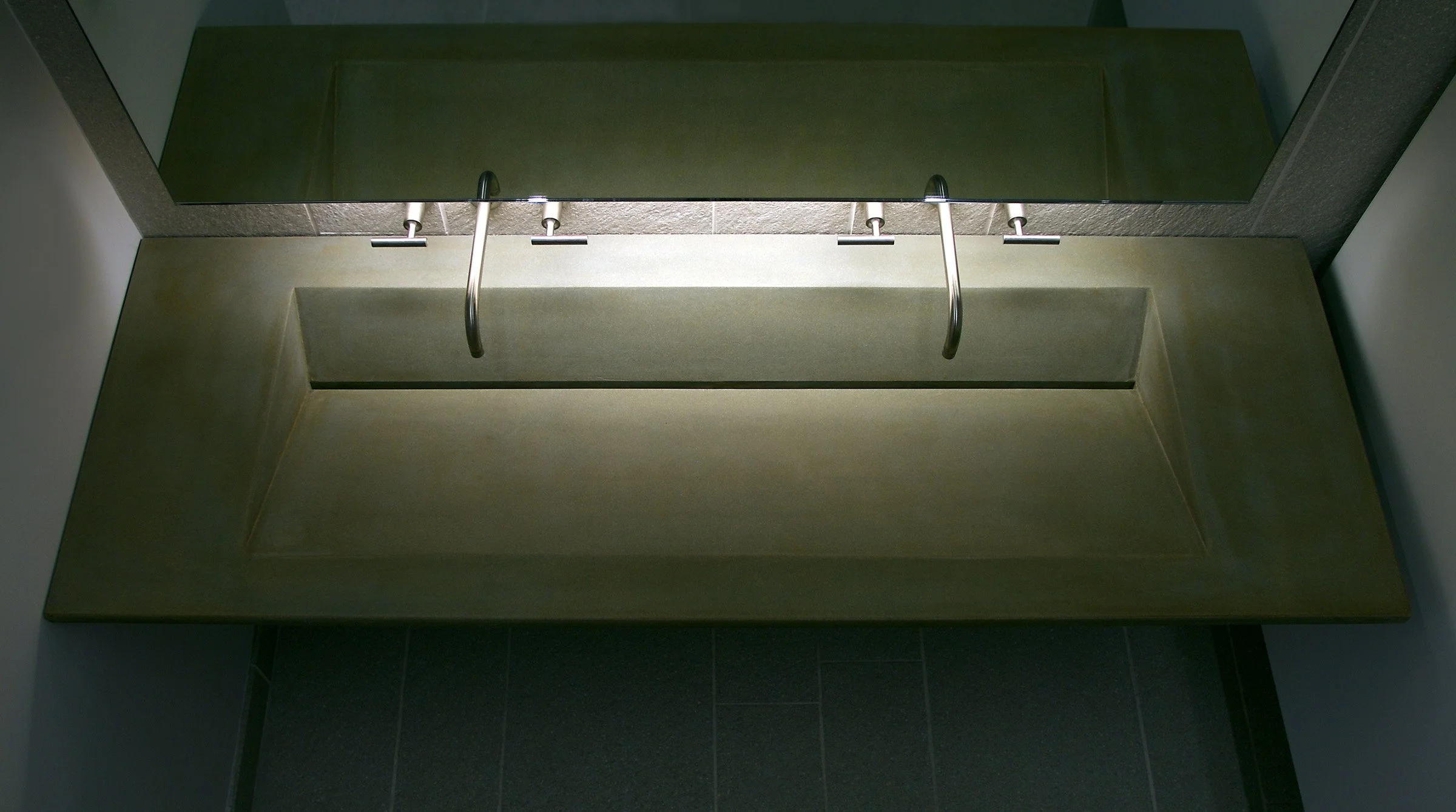 Modern bathroom sink with dual faucet layout and artisan ramp design.