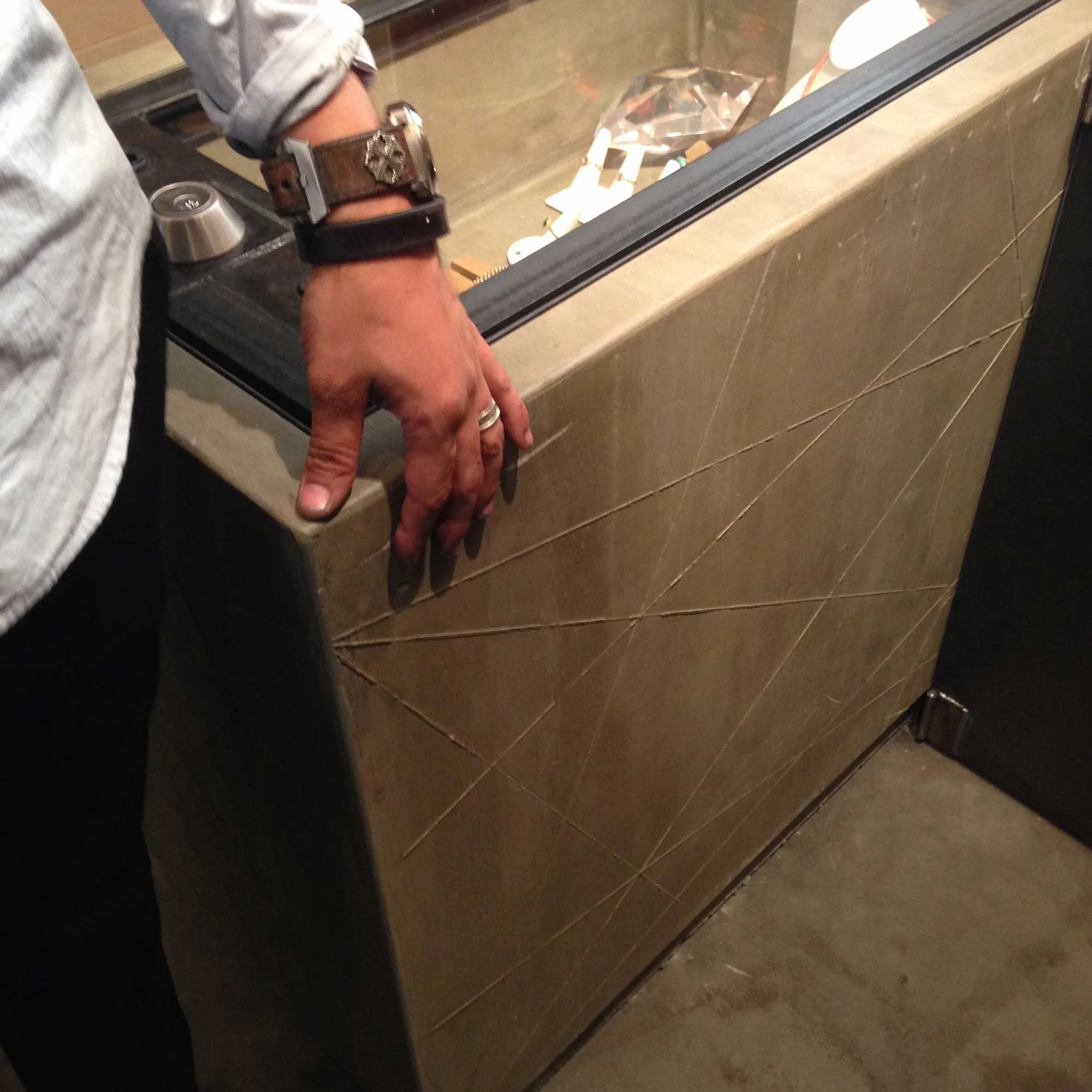 Board-formed concrete with kerf detailing on jewelry case.