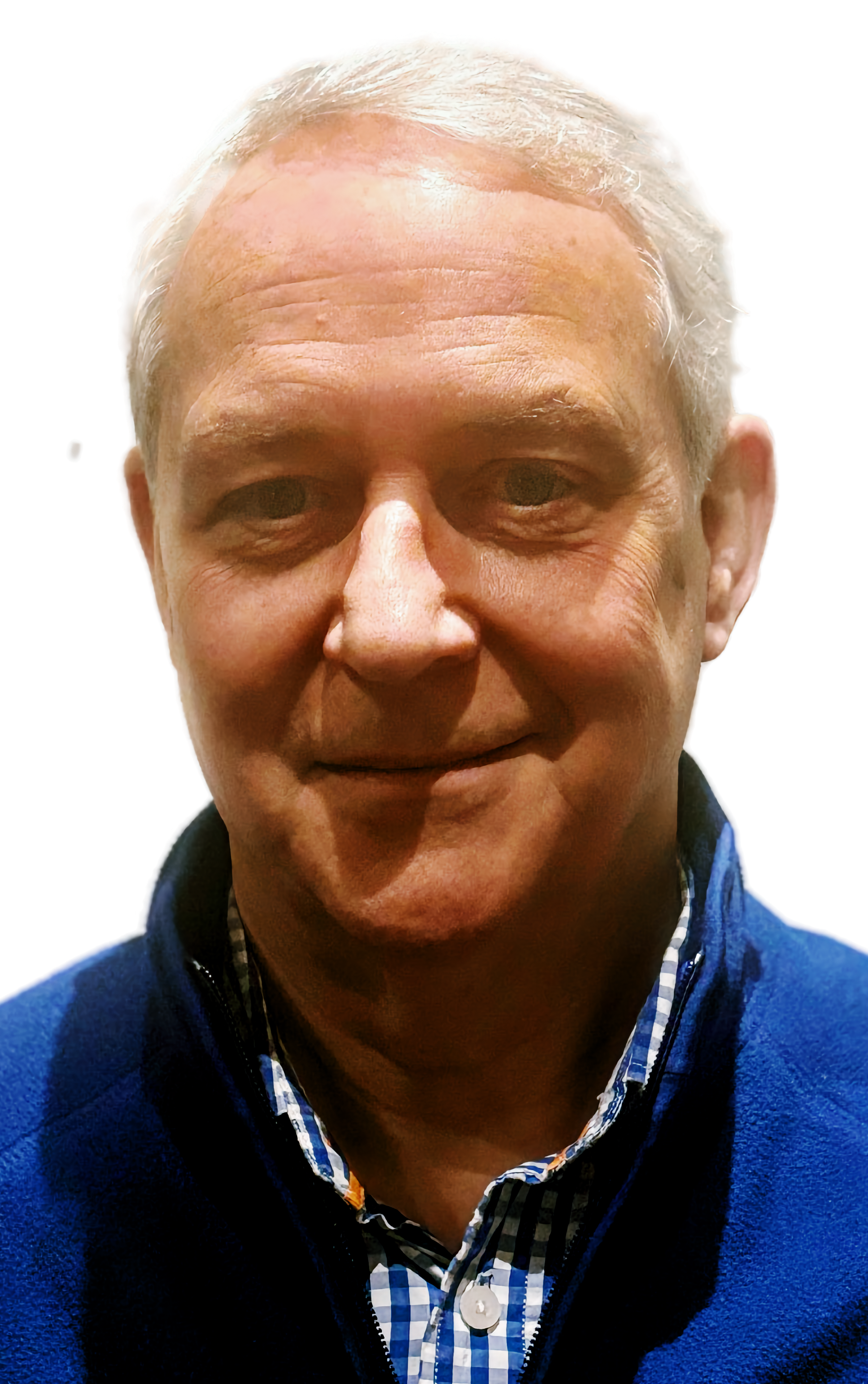 Close-up of an older man with light skin, gray hair, and a slight smile, wearing a blue jacket over a checkered shirt.