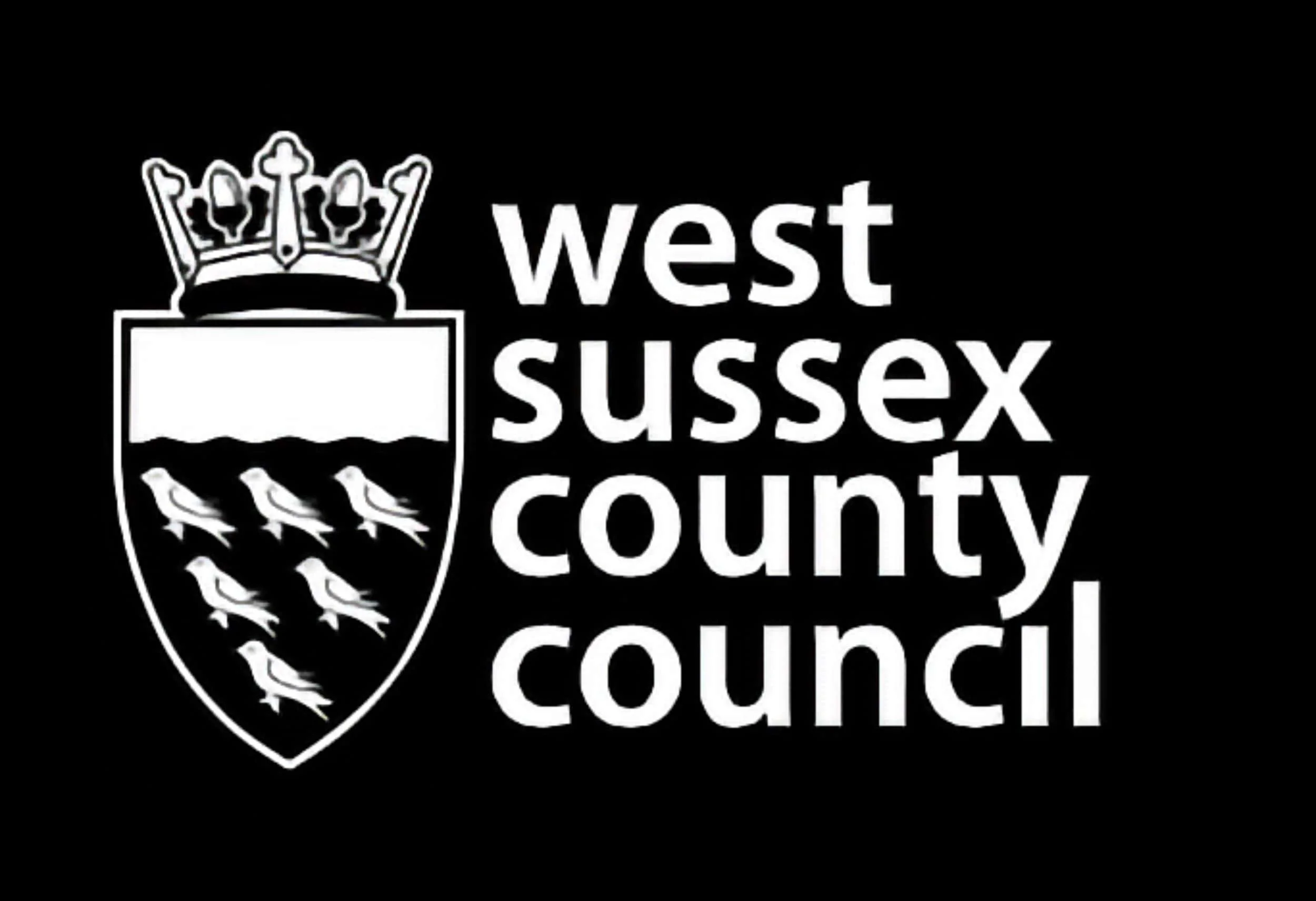 West Sussex County Council logo with a shield crest featuring a crown and birds, on a black background.