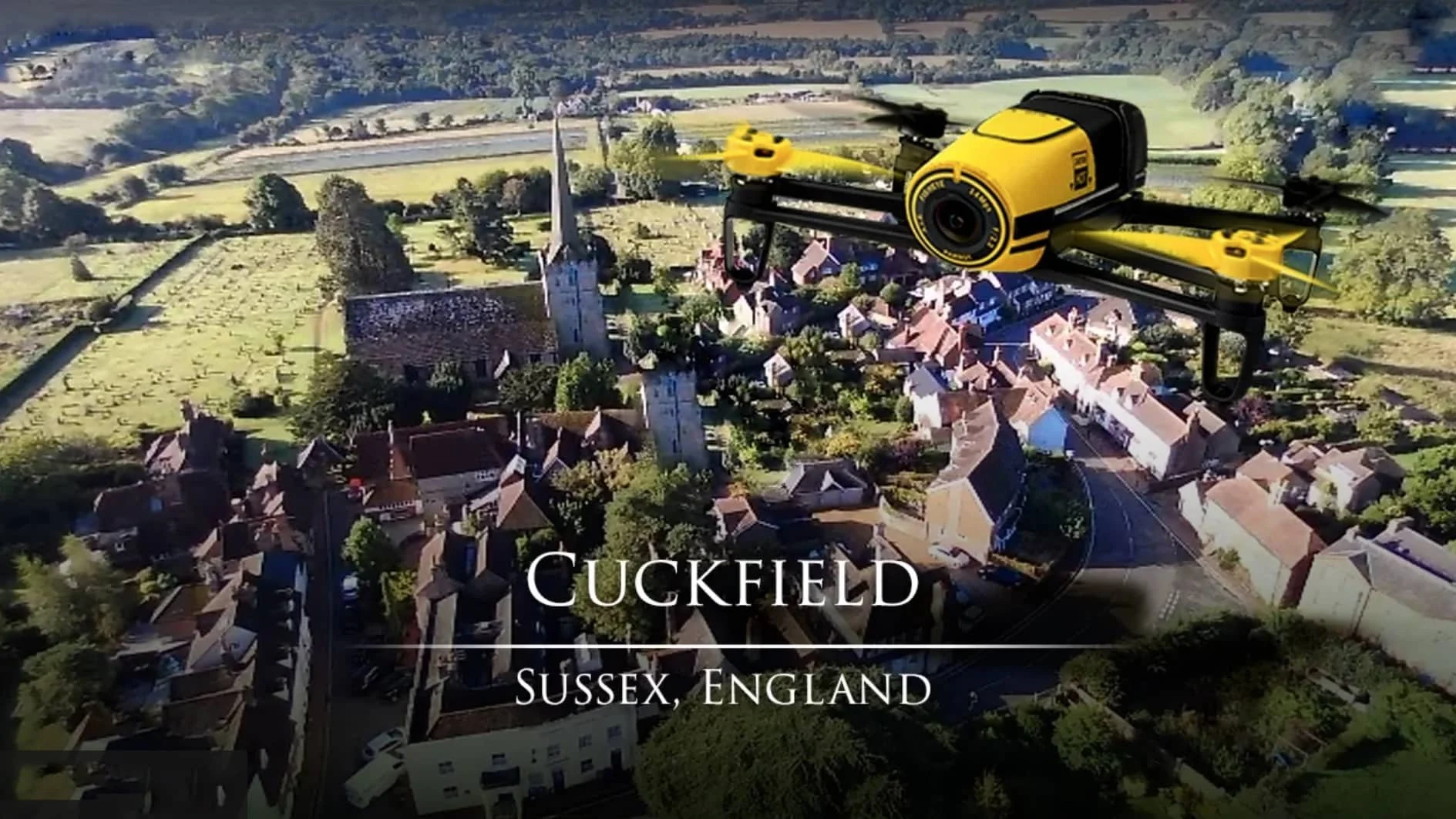 A drone flying over the village of Cuckfield in Sussex, England, with an overlay of a yellow and black drone on the image.