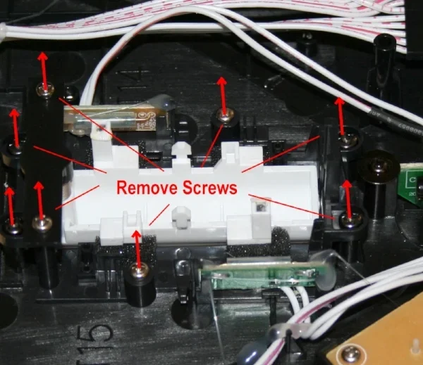Inside an electronic device with screws and wires, with red arrows indicating screw removal points and text that says 'Remove Screws'.