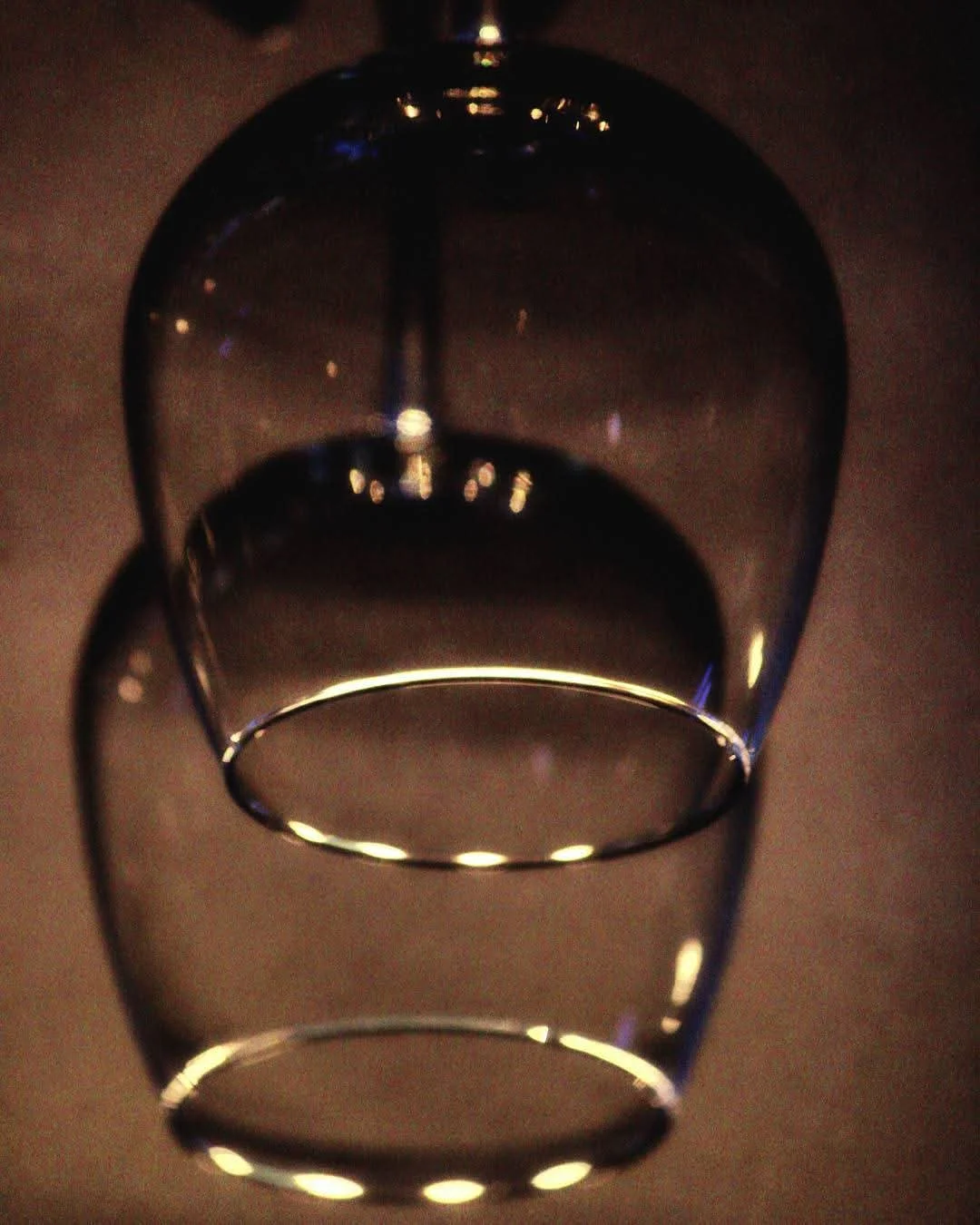 Empty transparent glass with a wide rim, shot from above, against a dark background.
